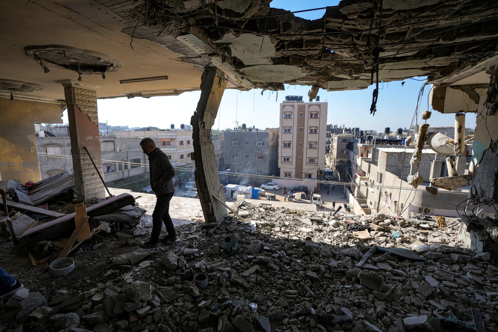 FILE - A Palestinian looks at a damaged residential building following an overnight Israeli strike in Deir al-Balah, Gaza Strip, on Jan. 8, 2025. (AP Photo/Abdel Kareem Hana, File)