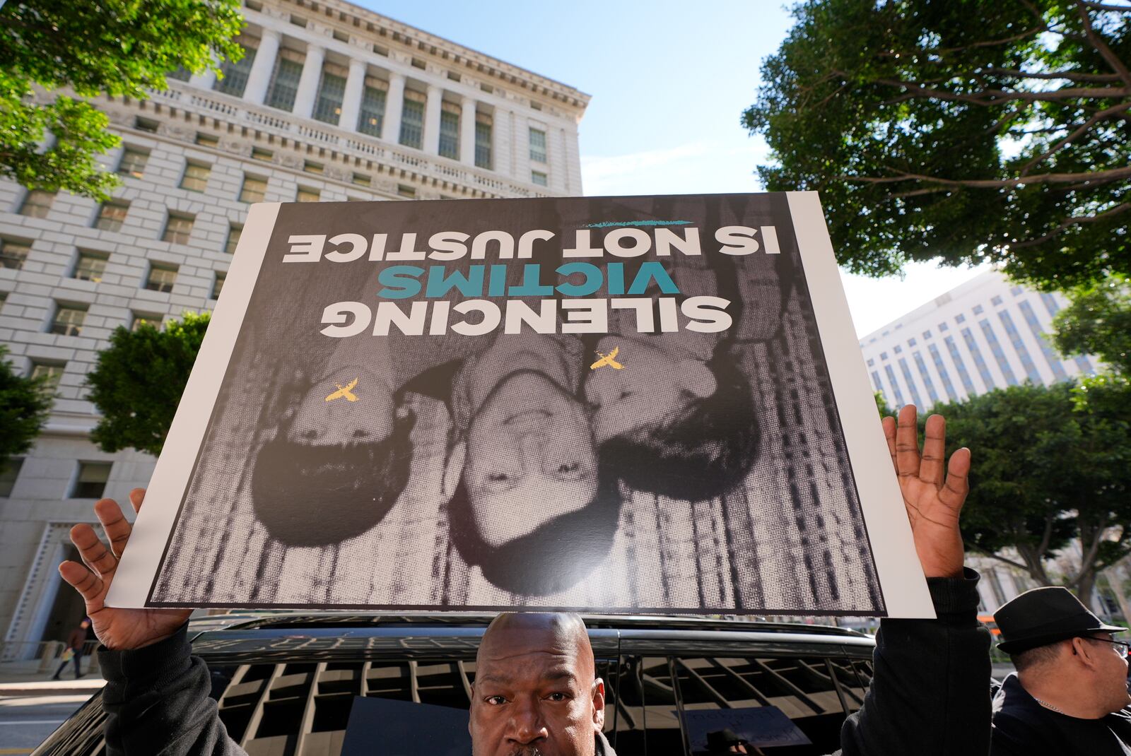 A supporter holds a sign during a press conference regarding developments in the Menendez brothers case Thursday, March 20, 2025, in Los Angeles. (AP Photo/Damian Dovarganes)