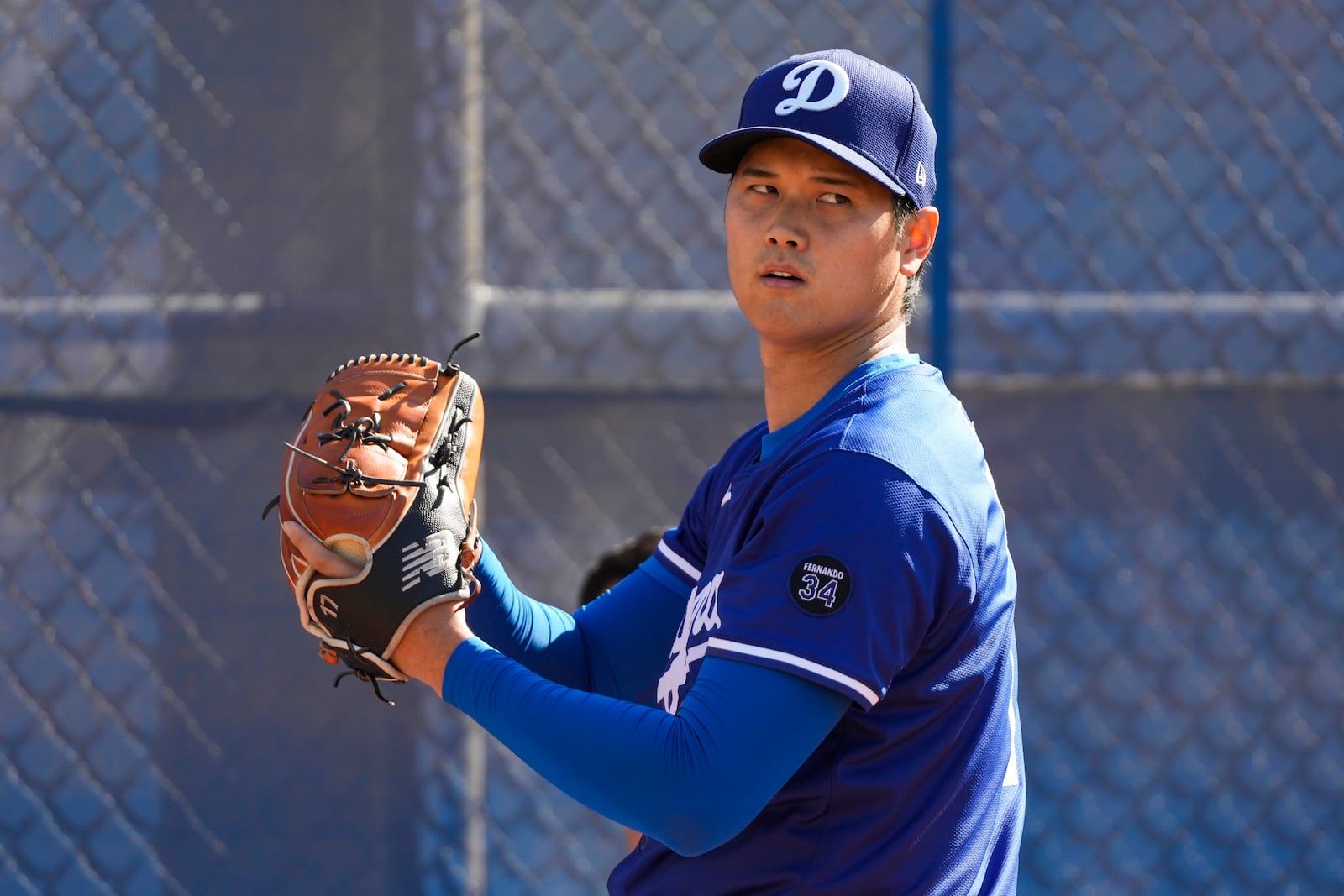 Los Angeles Dodgers two-way player Shohei Ohtani (17) throws in the bullpen during spring training baseball practice, Tuesday, Feb. 18, 2025, in Phoenix. (AP Photo/Ashley Landis)