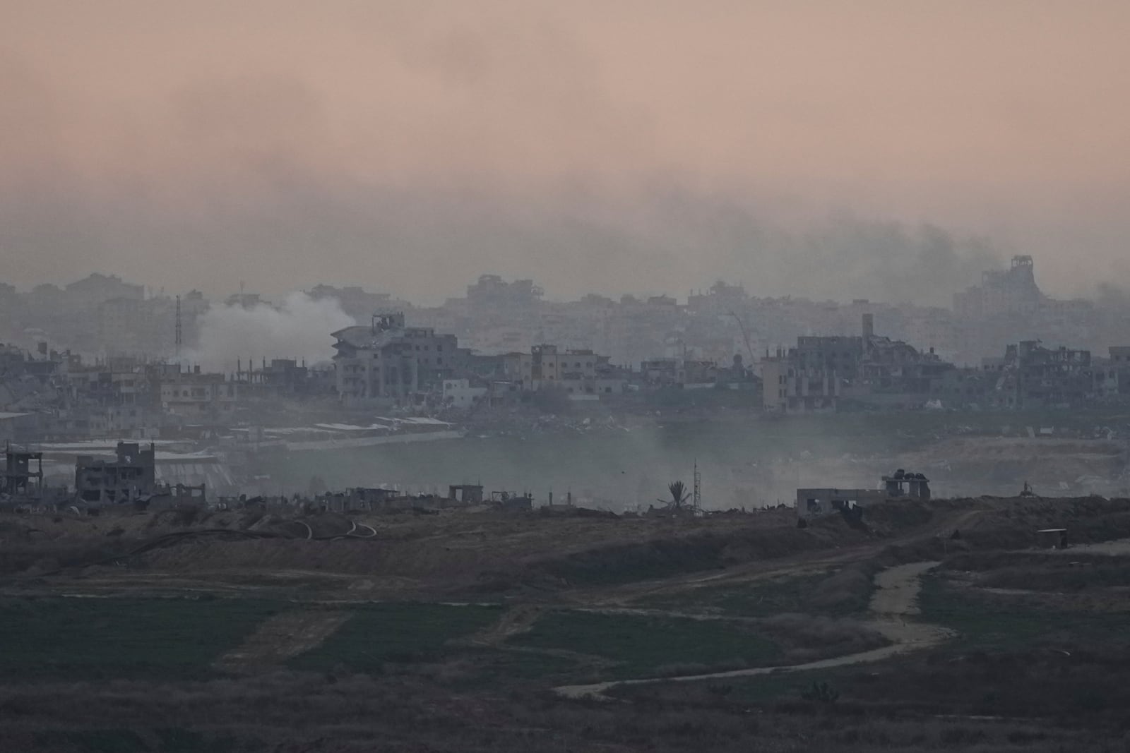 Destroyed buildings by Israeli bombardments are seen inside the Gaza Strip from southern Israel, on Tuesday, Jan. 14, 2025. (AP Photo/Tsafrir Abayov)