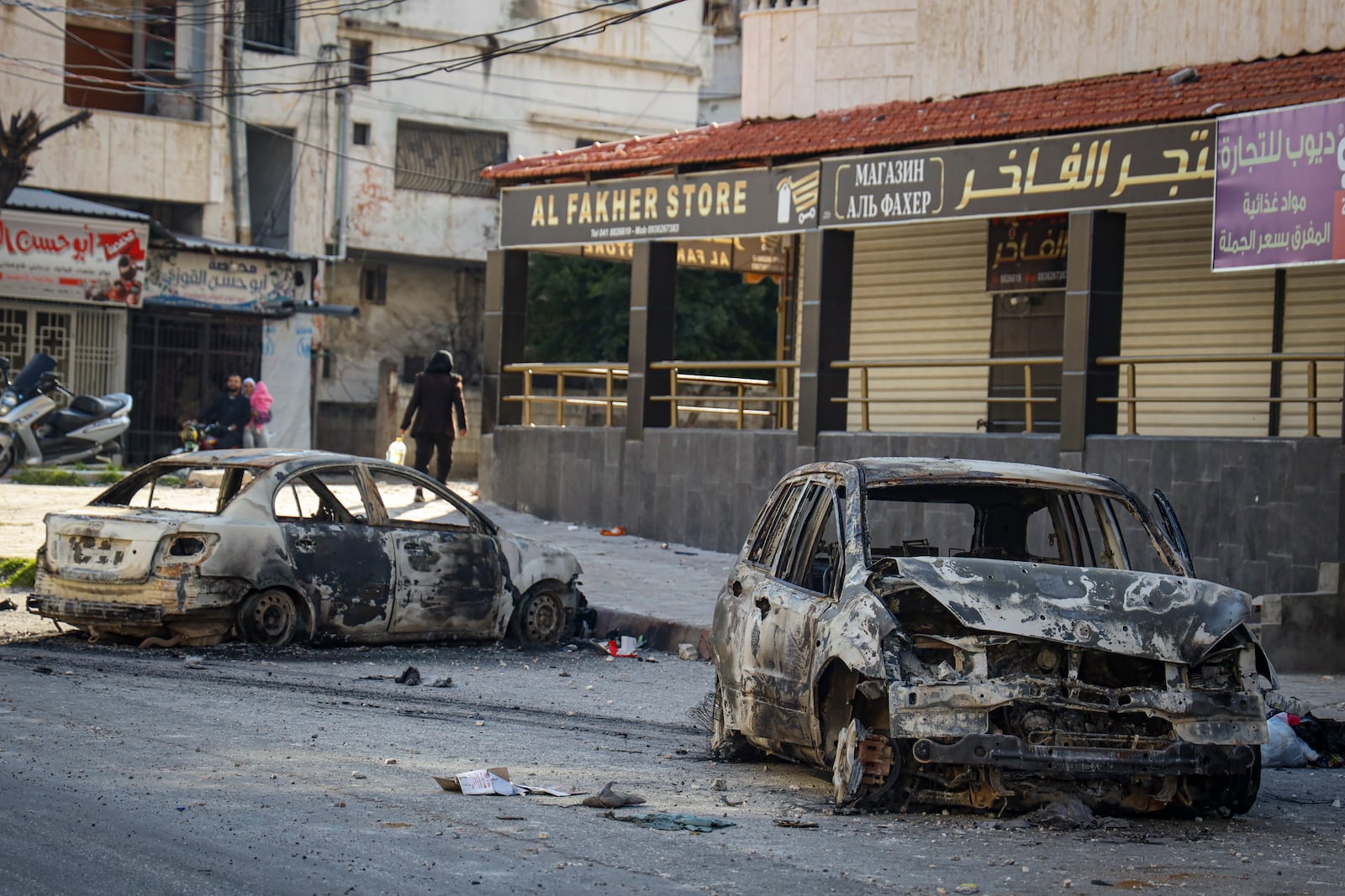 Burnt cars remain in the middle of a street following the recent wave of violence between Syrian security forces and gunmen loyal to former President Bashar Assad, as well as subsequent sectarian attacks, in the town of Jableh, Syria's coastal region, Monday, March 10, 2025. (AP Photo/Omar Albam)