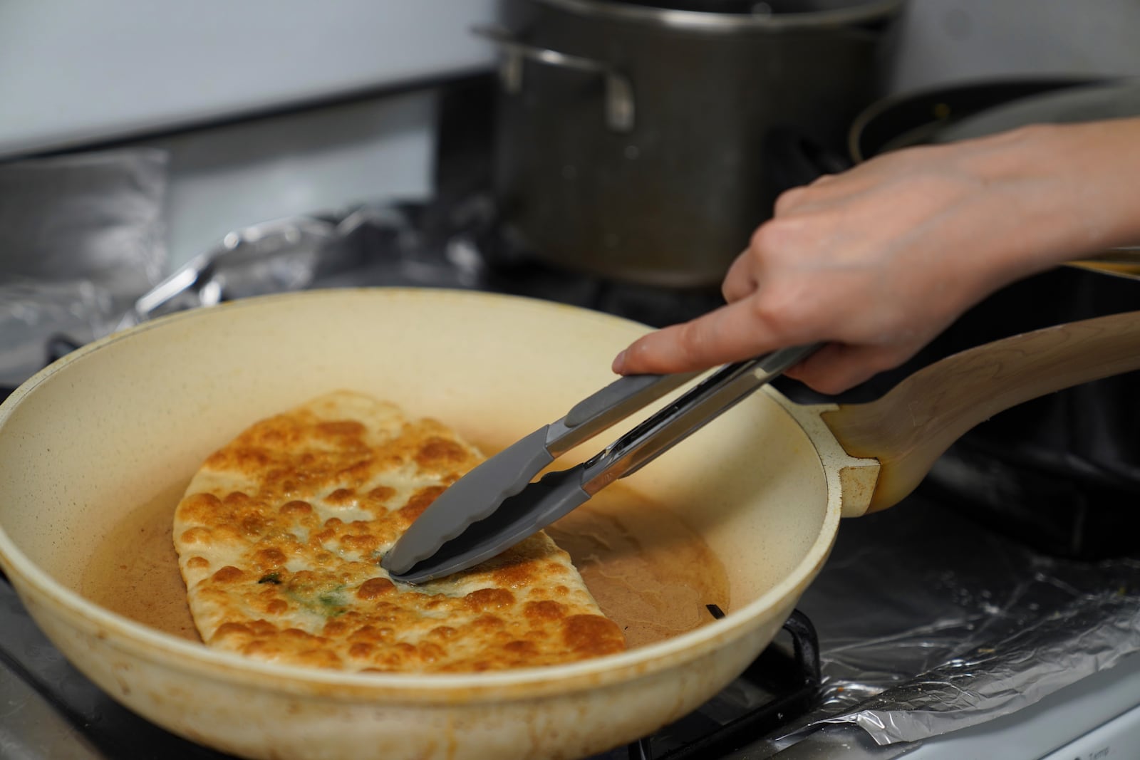 Maryam Rahimi prepares Bolani and other foods to break the daily fast during the Muslim holy month of Ramadan, in Alexandria, Va., Wednesday, March 5, 2025. (AP Photo/Jessie Wardarski)