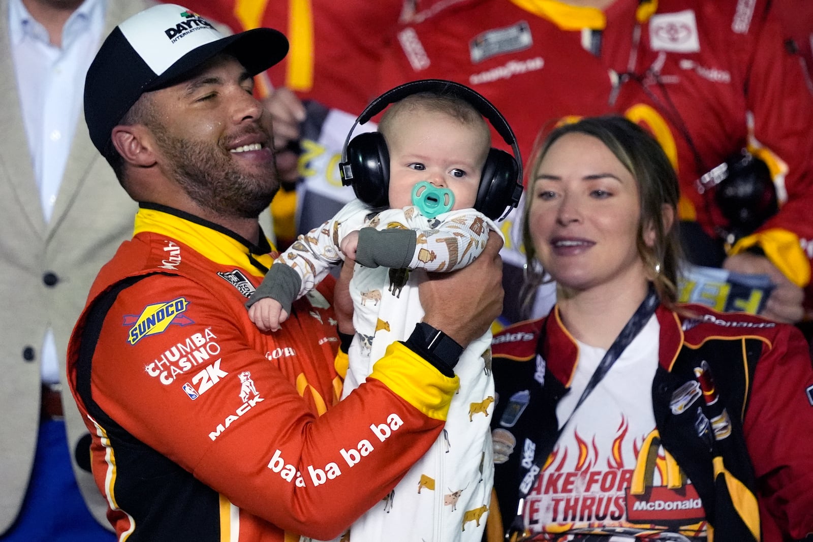 Bubba Wallace , left, celebrates in Victory lane with his son Becks Hayden and his wife Amanda Carter after winning the first of two NASCAR Daytona 500 qualifying auto races at Daytona International Speedway, Thursday, Feb. 13, 2025, in Daytona Beach, Fla. (AP Photo/John Raoux)