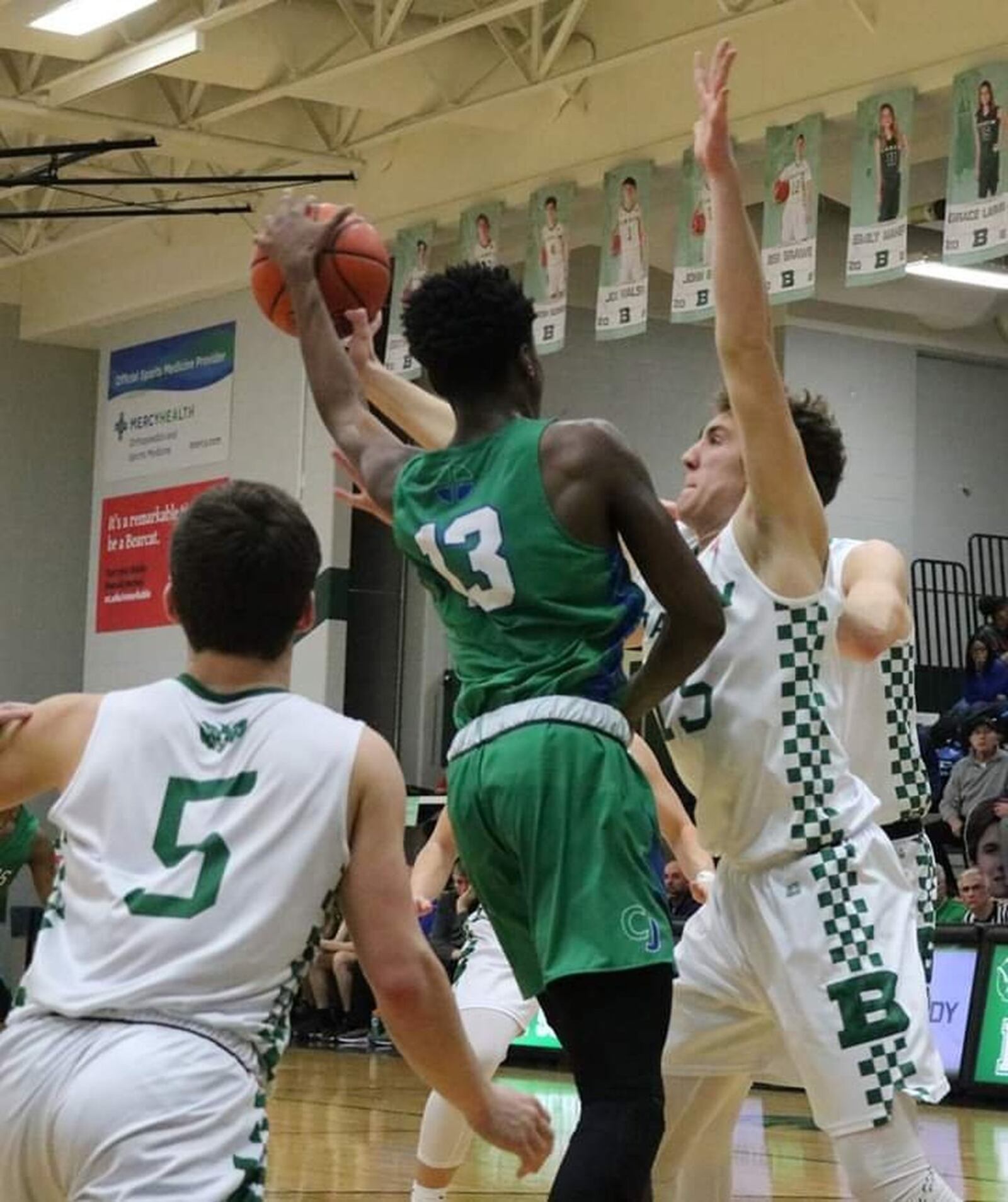 Chaminade Julienne’s Brandon Gibson (13) works inside against Badin’s John Berg (15) and Donovan Watkins (5) during Friday night’s game at Mulcahey Gym in Hamilton. CJ won 58-54. CONTRIBUTED PHOTO BY TERRI ADAMS