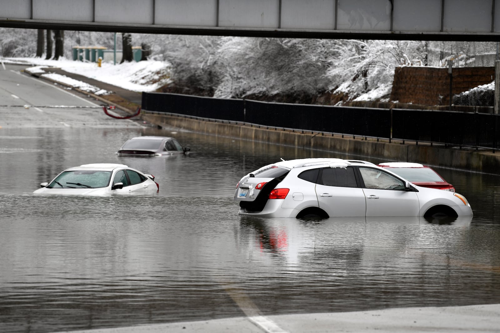 Cars sit in floodwaters at a railroad underpass in Louisville, Ky., Sunday, Feb. 16, 2025. (AP Photo/Timothy D. Easley)