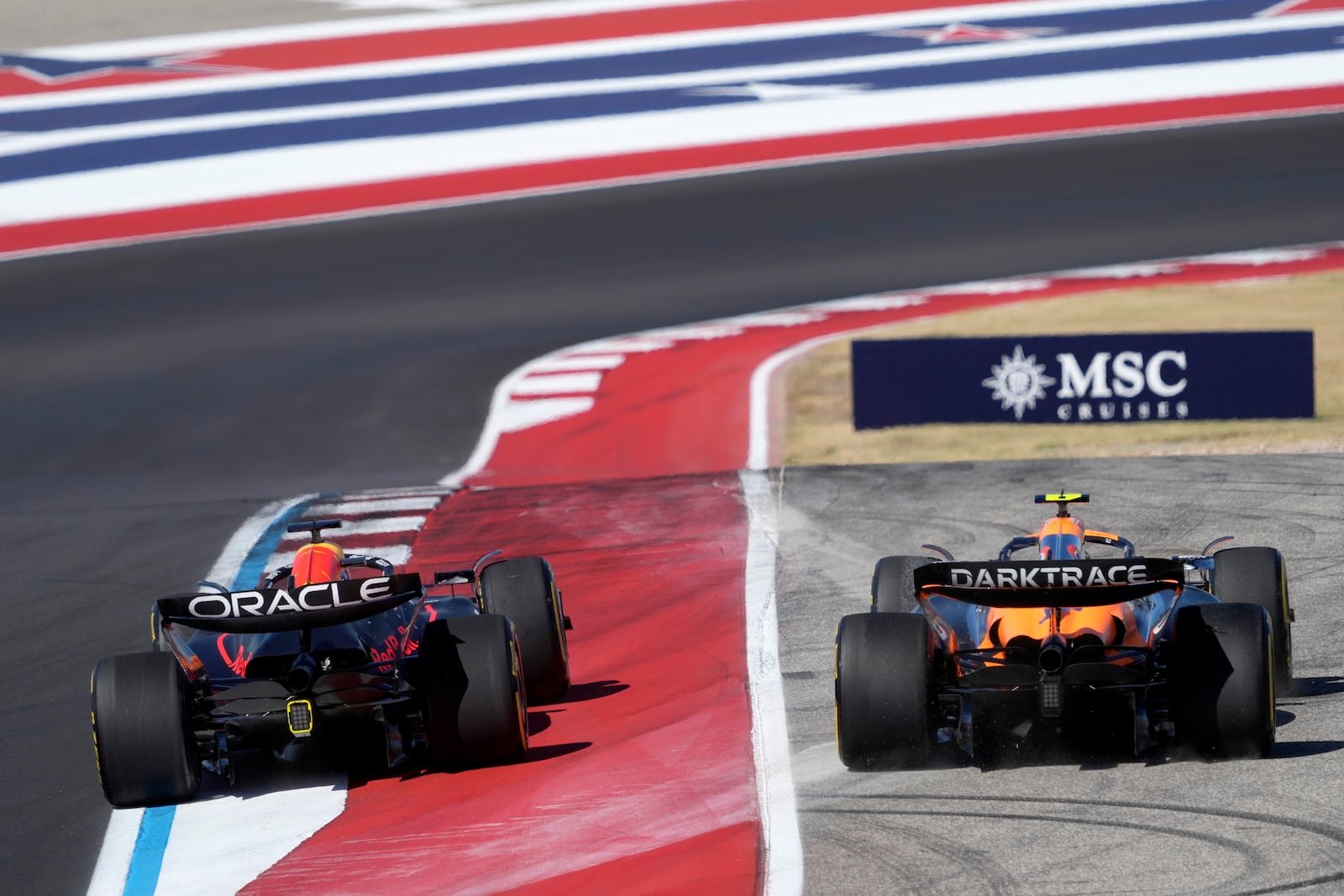 Red Bull driver Max Verstappen, left, of the Netherlands, runs McLaren driver Lando Norris, right, of Britain, off the track at Turn 1 during the U.S. Grand Prix auto race at Circuit of the Americas, Sunday, Oct. 20, 2024, in Austin, Texas. (AP Photo/Eric Gay)