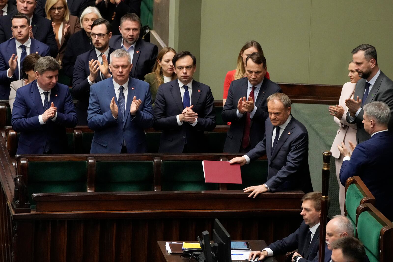 Polish Prime Minister Donald Tusk, right, after speaking at the Sejm, the lower house of parliament, in Warsaw, Poland, Friday March 7, 2025. (AP Photo/Czarek Sokolowski)