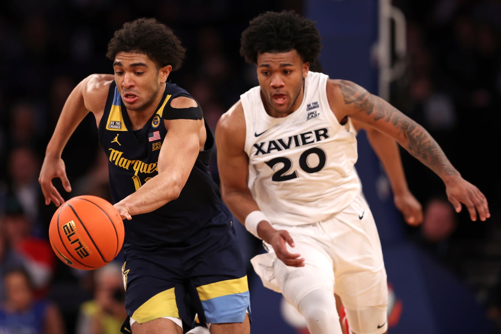 Marquette guard Stevie Mitchell, left, dribbles past Xavier guard Dayvlon McKnight (20) during the second half of an NCAA college basketball game in the quarterfinals of the Big East Conference tournament, Thursday, March 13, 2025, in New York. (AP Photo/Pamela Smith)