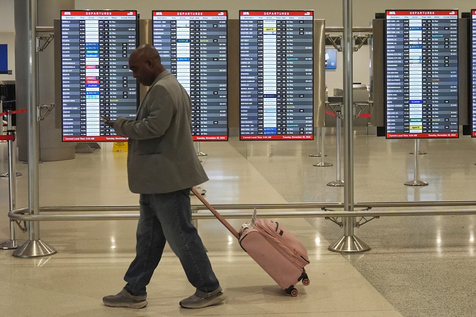 A traveler walks to his gate at Miami International Airport, Tuesday, Nov. 26, 2024, in Miami. (AP Photo/Marta Lavandier)