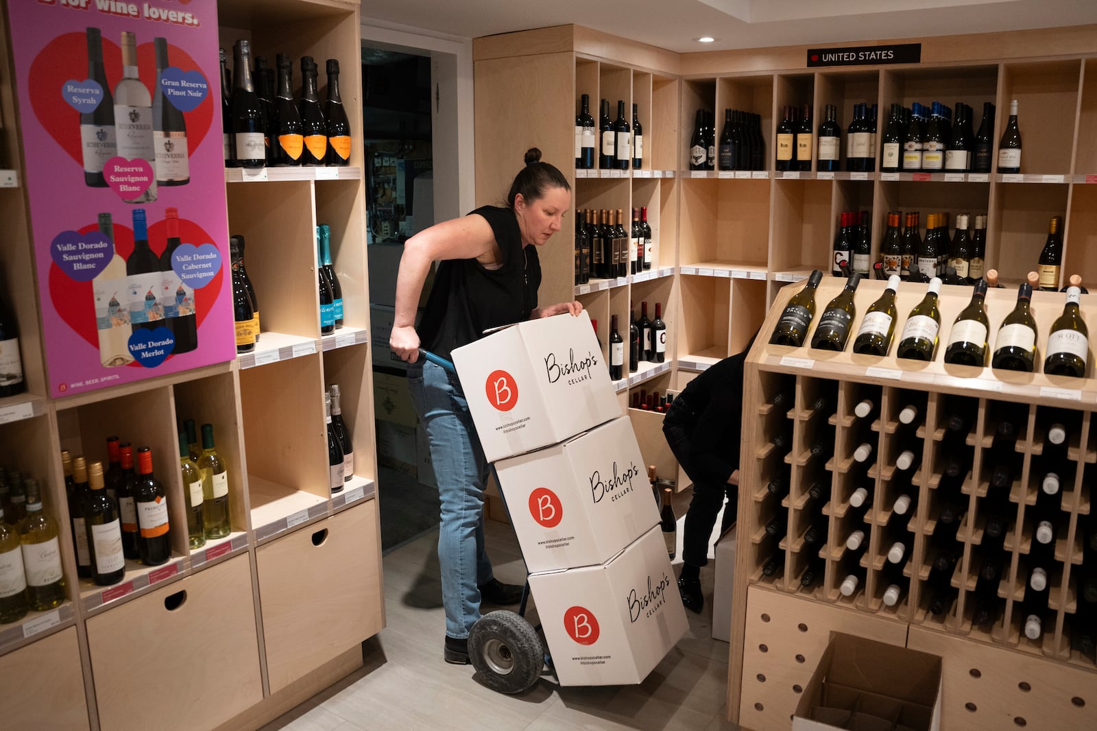 Employees remove American-made wine from their shelves at Bishop's Cellar in Halifax on Wednesday, March 5, 2025. (Darren Calabrese /The Canadian Press via AP)