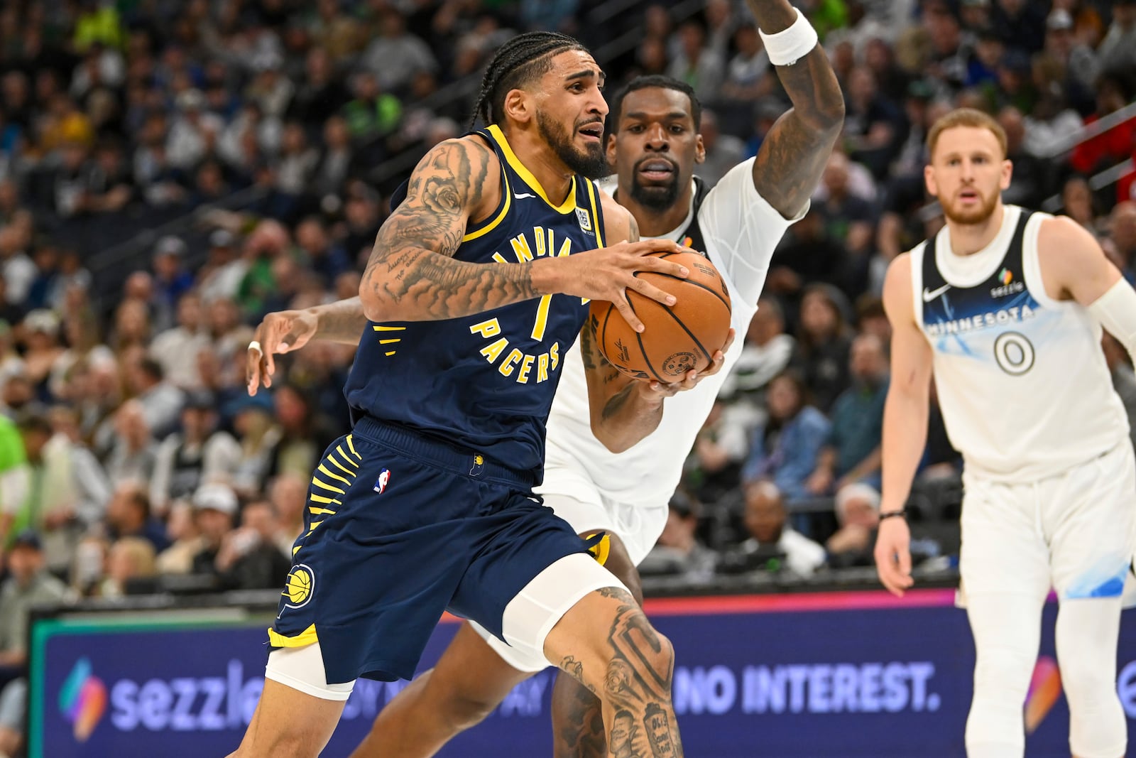 Indiana Pacers forward Obi Toppin, left, drives past Minnesota Timberwolves center Naz Reid during the first half of an NBA basketball game Monday, March 17, 2025, in Minneapolis. (AP Photo/Craig Lassig)