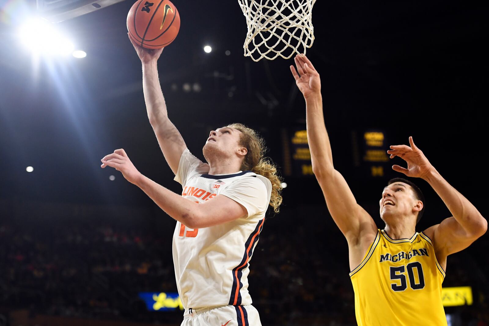 Illinois forward Jake Davis, left, scores a basket past Michigan center Vladislav Goldin during the first half of an NCAA college basketball game, Sunday, March 2, 2025, in Ann Arbor, Mich. (AP Photo/Jose Juarez)