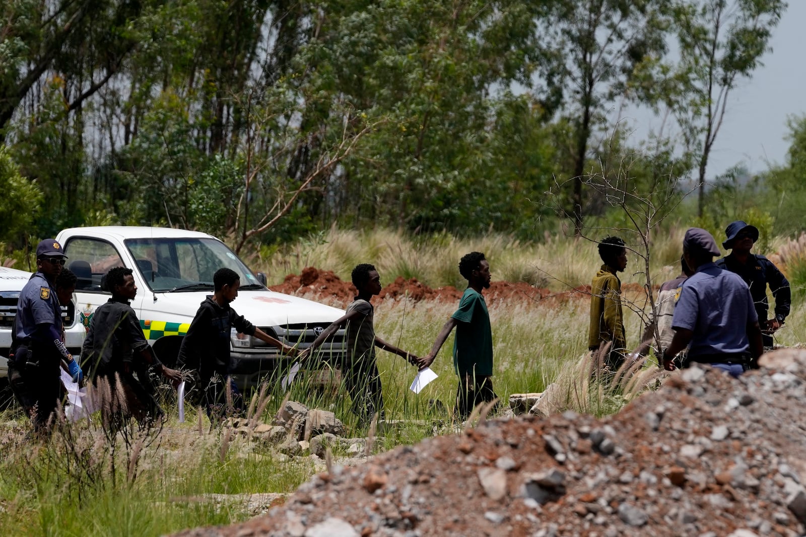 Illegal miners escorted by police officers after being rescued from an abandoned gold mine in Stilfonteinin, South Africa, Tuesday, Jan. 14, 2025. (AP Photo/Themba Hadebe)