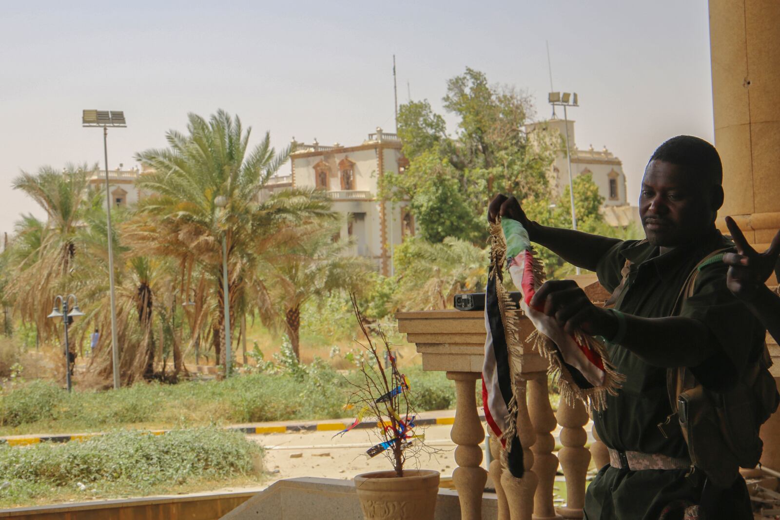 A Sudan army soldier holds a national flag to celebrate after the army take over the Republican Palace in Khartoum, Sudan, Friday, March 21, 2025. (AP Photo)