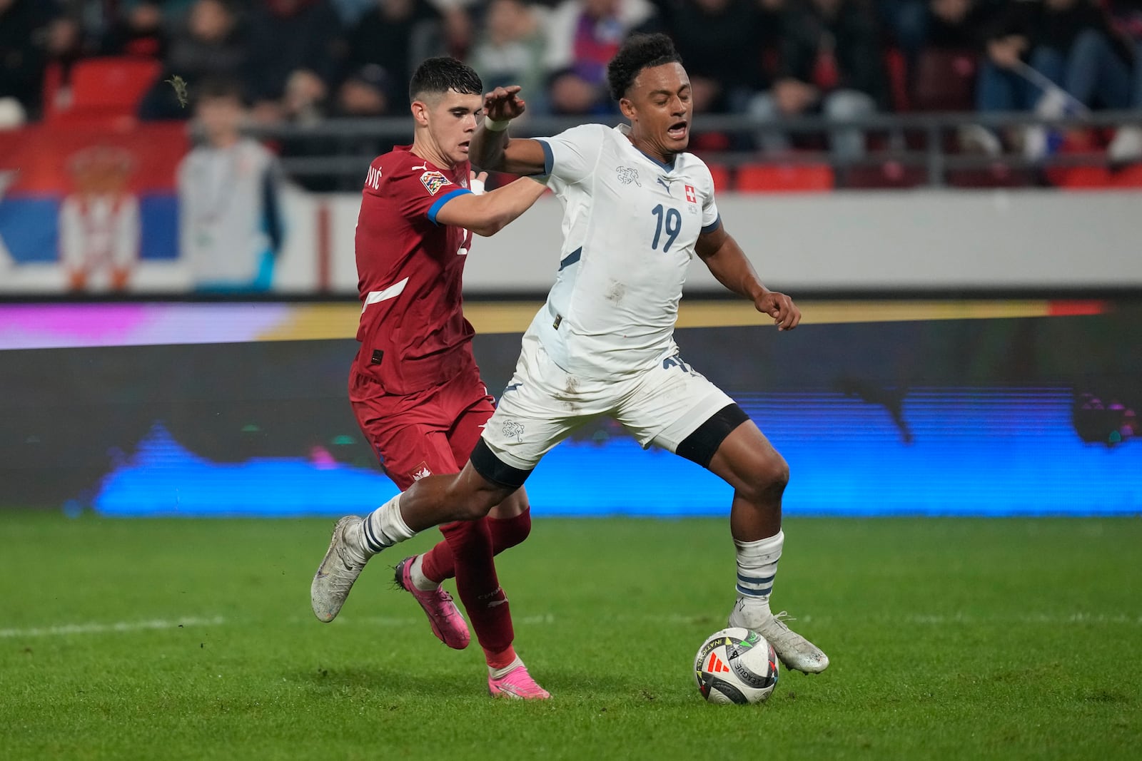 Serbia's Kosta Nedeljkovic fouls Switzerland's Dan Ndoye inside the penalty box during the UEFA Nations League soccer match between Serbia and Switzerland at the Dubocica Stadium in Leskovac, Serbia, Saturday, Oct. 12, 2024. (AP Photo/Darko Vojinovic)