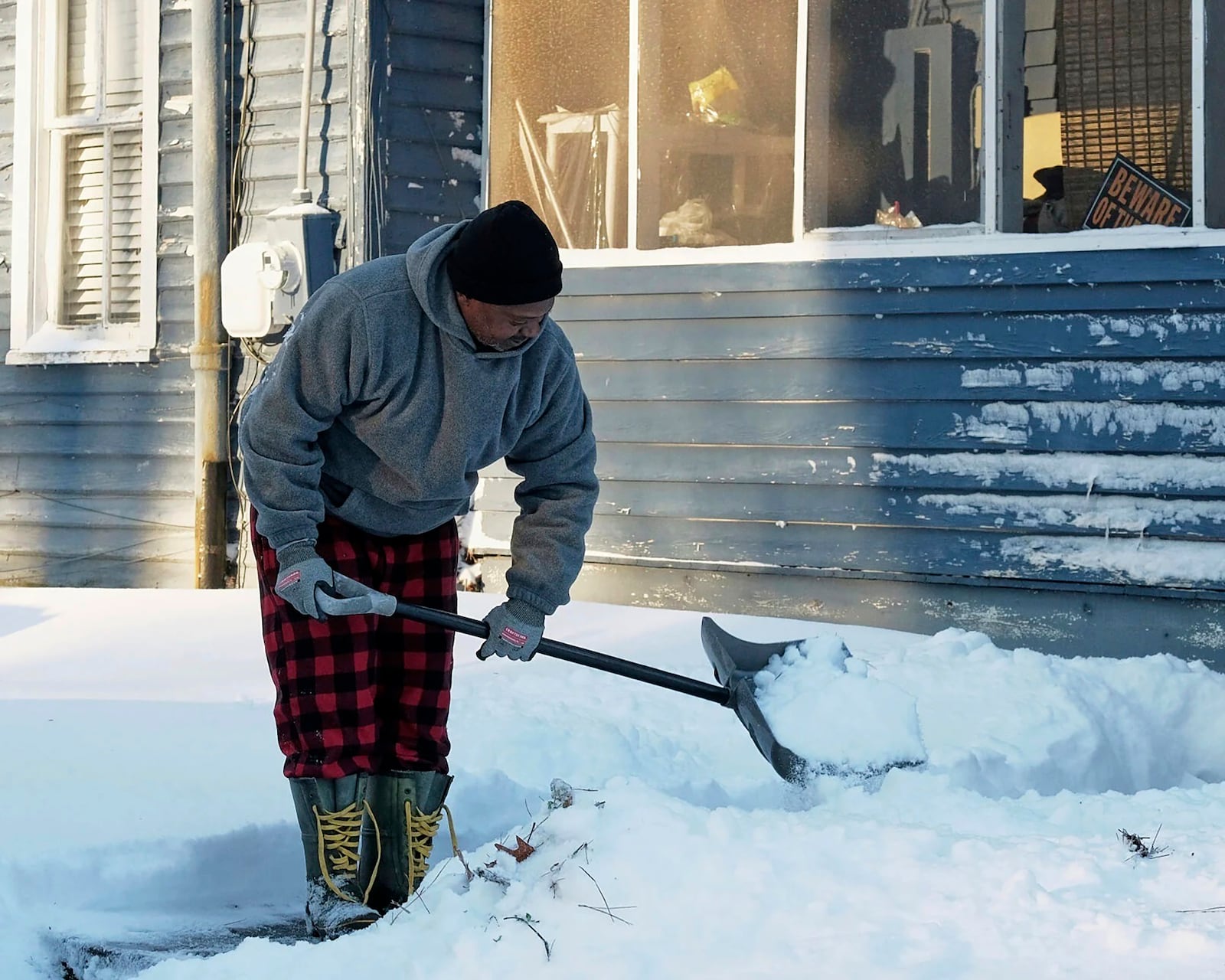 Derrick Tillett shovels the snow off the sidewalk leading from his house to the street in Elizabeth City, N.C., Thursday, Feb. 20, 2025. (Chris Day/The Daily Advance via AP)