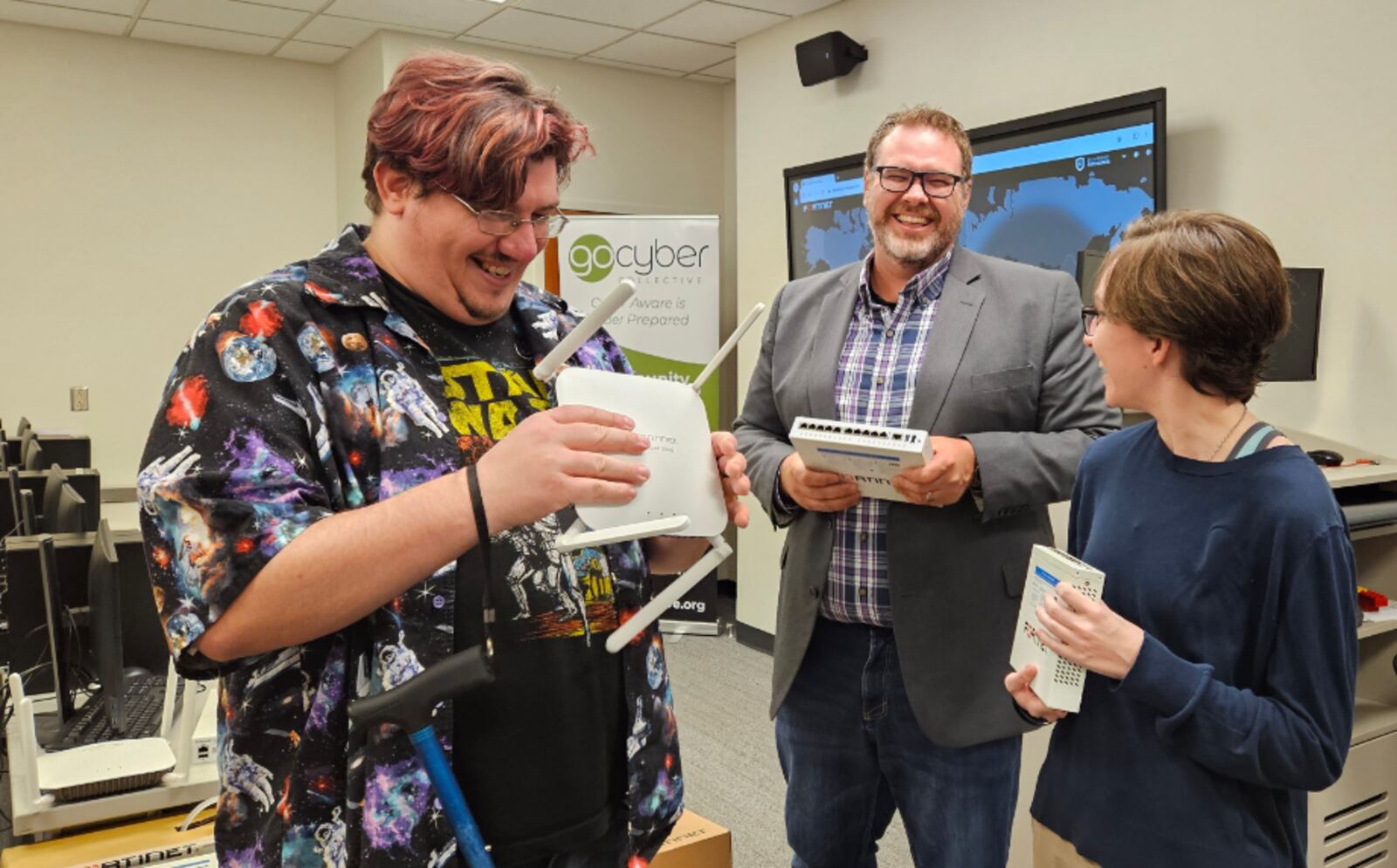 Kyle Jones (center), Chair of Sinclair’s Computer Science and Information Technology Department, shows new firewall equipment from Secure Cyber Defense to Sinclair students Adam Aaranson and Meghan Ripper. SINCLAIR/CONTRIBUTED