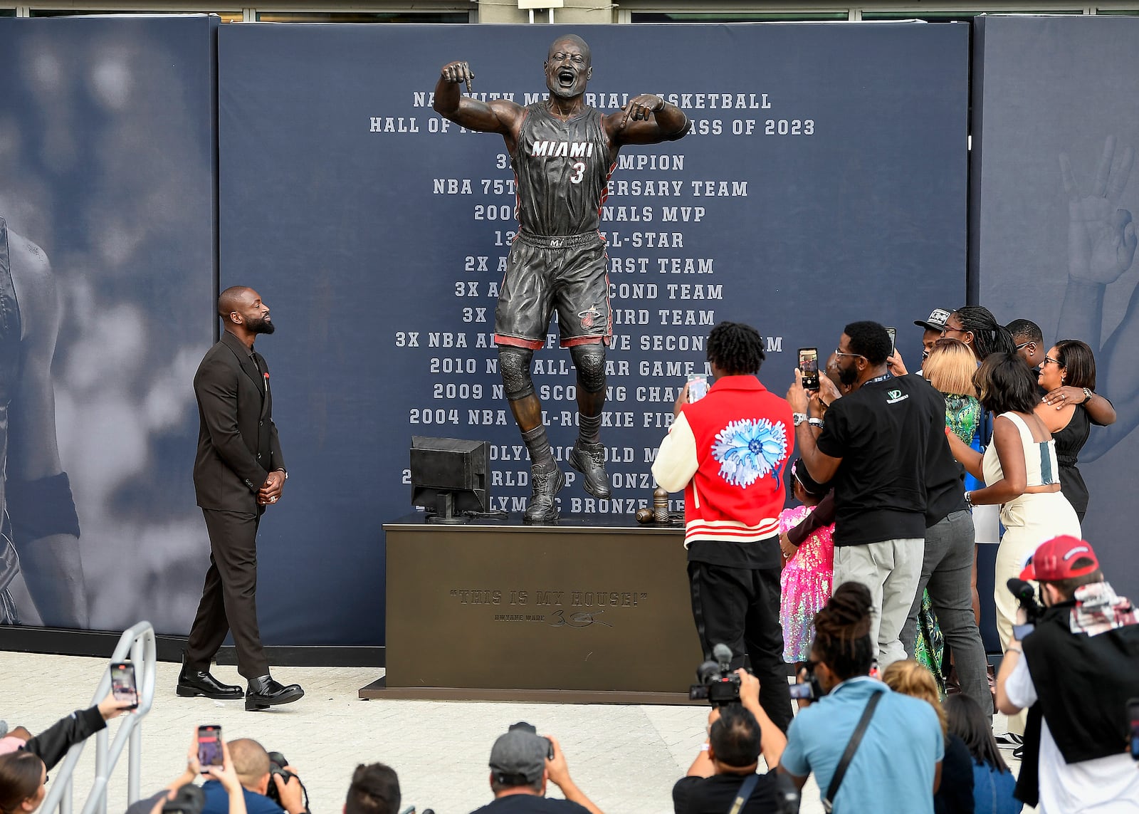 Former Miami Heat NBA basketball player Dwyane Wade, upper left, looks at a bronze statue of himself during a statue unveiling ceremony outside the Kaseya Center, Sunday, Oct. 27, 2024, in Miami, Fla. (AP Photo/Michael Laughlin)