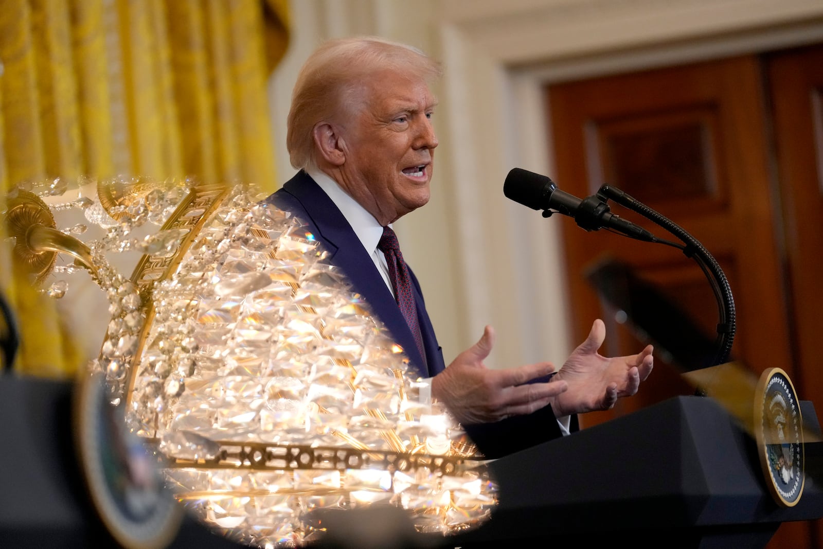 President Donald Trump speaks as a chandelier is reflected in the teleprompter glass during a news conference with India's Prime Minister Narendra Modi in the East Room of the White House, Thursday, Feb. 13, 2025, in Washington. (AP Photo/Ben Curtis)