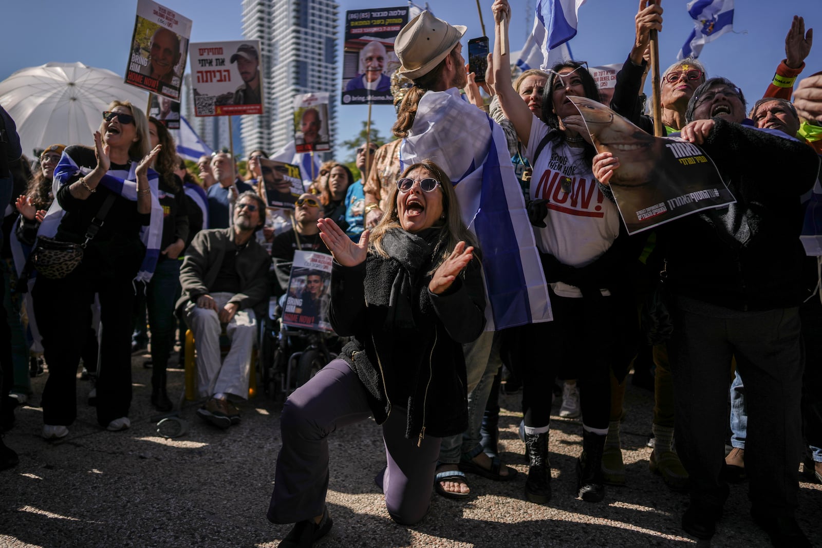 Israelis react at the so-called 'Hostages Square' as they watch a live Gaza broadcast of the release of three Israeli men held hostage in Tel Aviv, Israel, on Saturday, Feb. 15, 2025. (AP Photo/Oded Balilty)