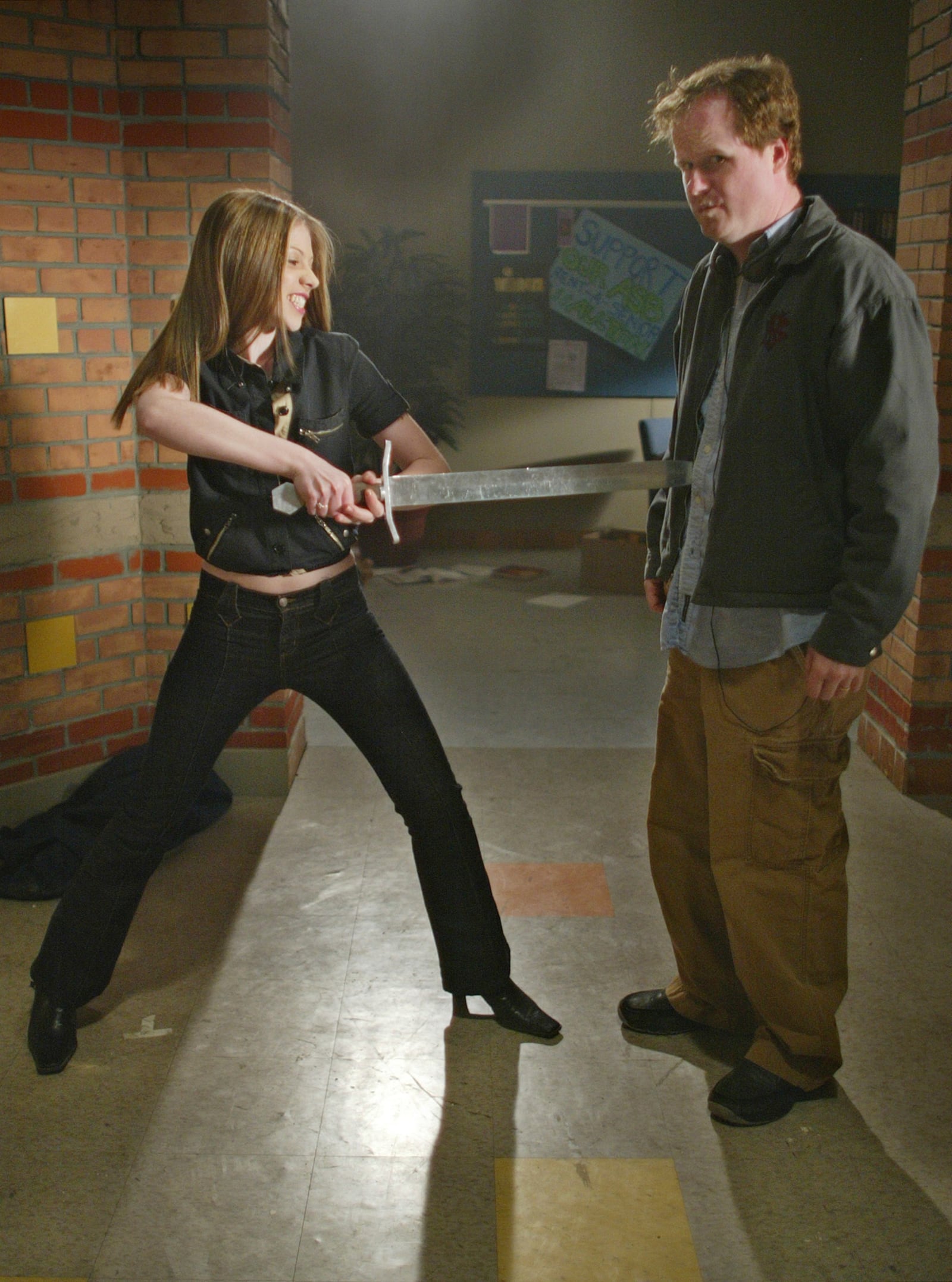 FILE - Actor Michelle Trachtenberg, left, who portrays Dawn, Buffy's sister Emmy, playfully spears series producer-creator Joss Whedon, during the taping of the final episode of "Buffy the Vampire Slayer" in Santa Monica, Calif., April 16, 2003. (AP Photo/Damian Dovarganes, File)