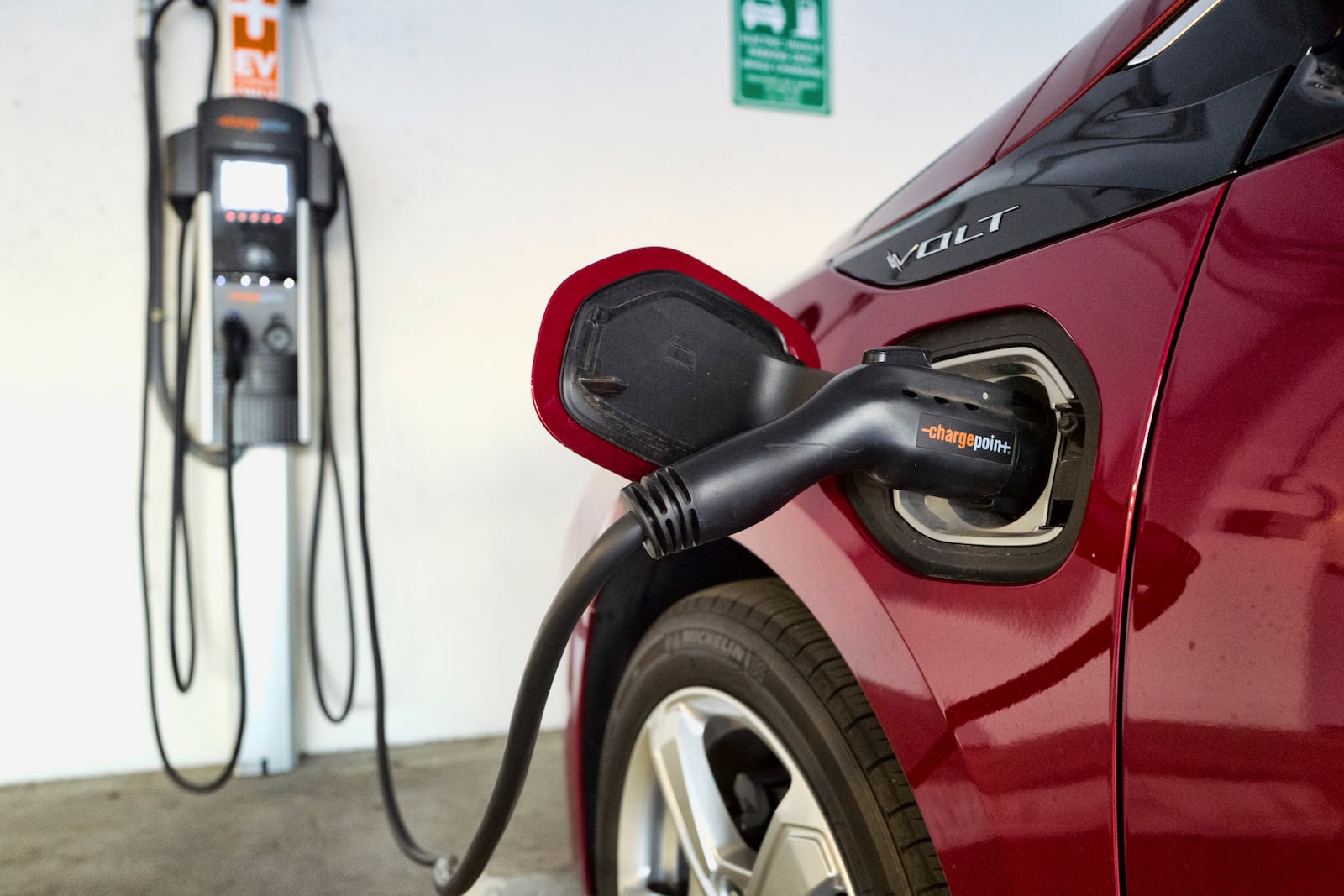 FILE - An electric vehicle is charged at a parking garage in Los Angeles, Oct. 17, 2018. (AP Photo/Richard Vogel, File)