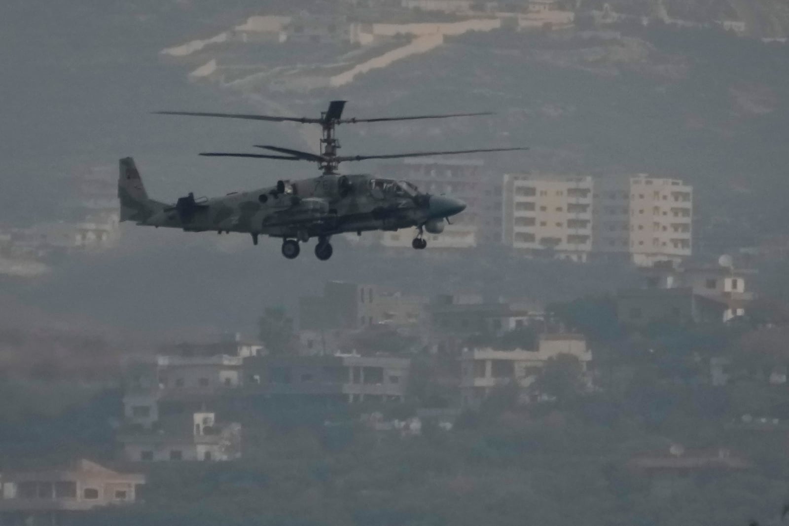 A Russian helicopter flies over the Hmeimim Air Base, a Syrian airbase currently operated by Russia, located southeast of the city of Latakia in the town of Hmeimim, Syria, on Monday, Dec.16, 2024. (AP Photo/Leo Correa)