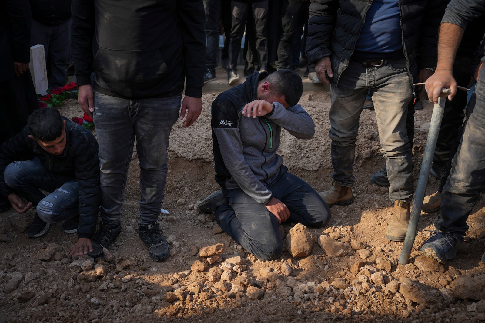 Mourners react next to the grave of 23-year-old hostage Hamzah AlZayadni during his funeral in the Bedouin city of Rahat, southern Israel, Friday, Jan. 10, 2025. AlZayadni was in Hamas captivity in the Gaza Strip. Israel's army said his body was recovered in an underground tunnel in southern Gaza. (AP Photo/Ariel Schalit)