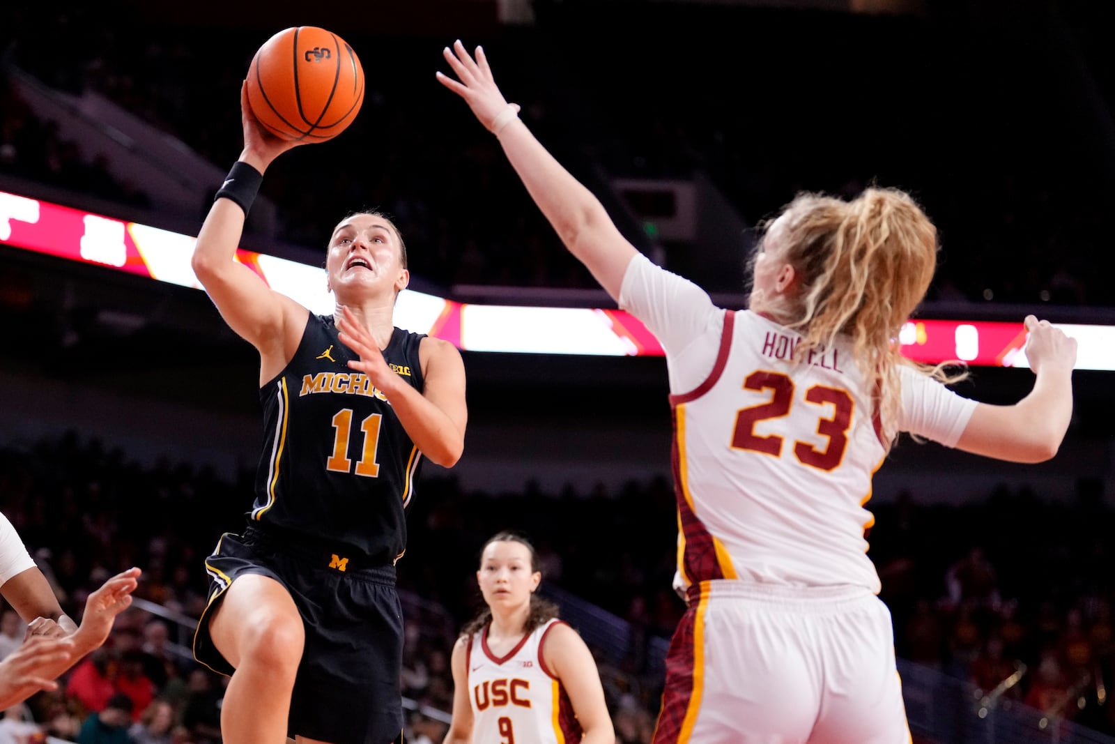 Michigan guard Greta Kampschroeder, left, shoots as Southern California guard Avery Howell defends during the first half of an NCAA college basketball game, Sunday, Dec. 29, 2024, in Los Angeles. (AP Photo/Mark J. Terrill)