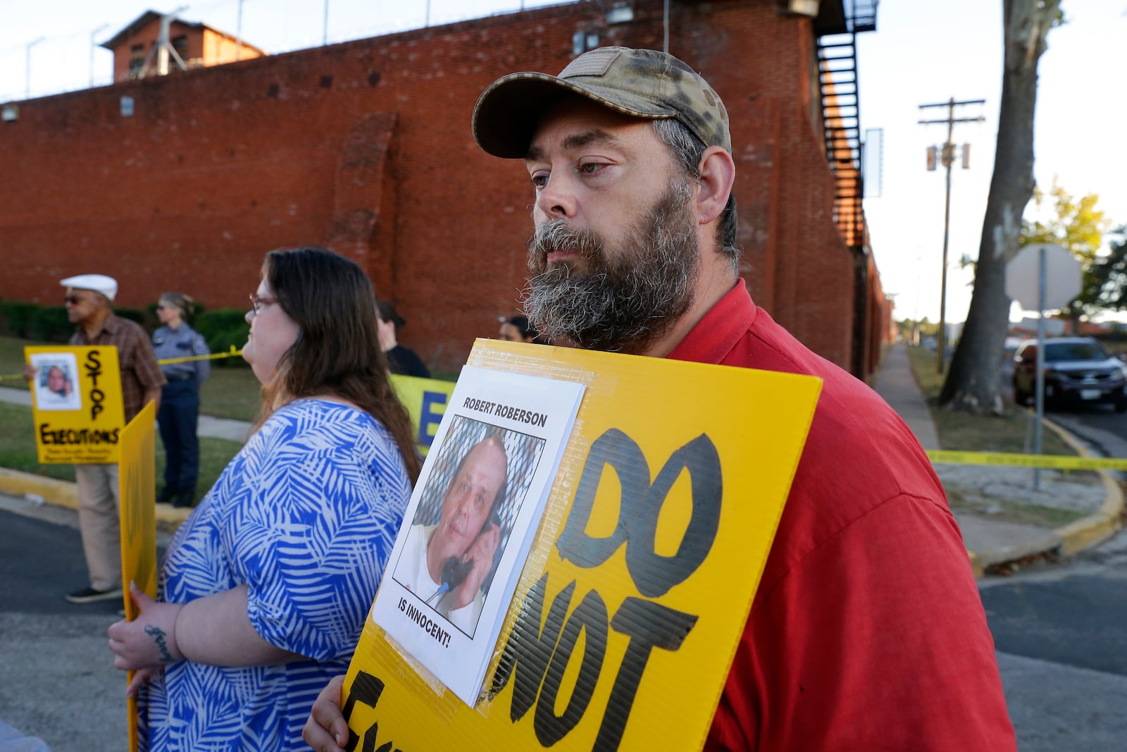 Thomas Roberson, right, older brother of condemned prisoner Robert Roberson, and Jennifer Martin, center left, holds signs with others as they protest outside the prison where Roberson is scheduled for execution at the Huntsville Unit of the Texas State Penitentiary Thursday, Oct. 17, 2024, in Huntsville, Texas. (AP Photo/Michael Wyke)