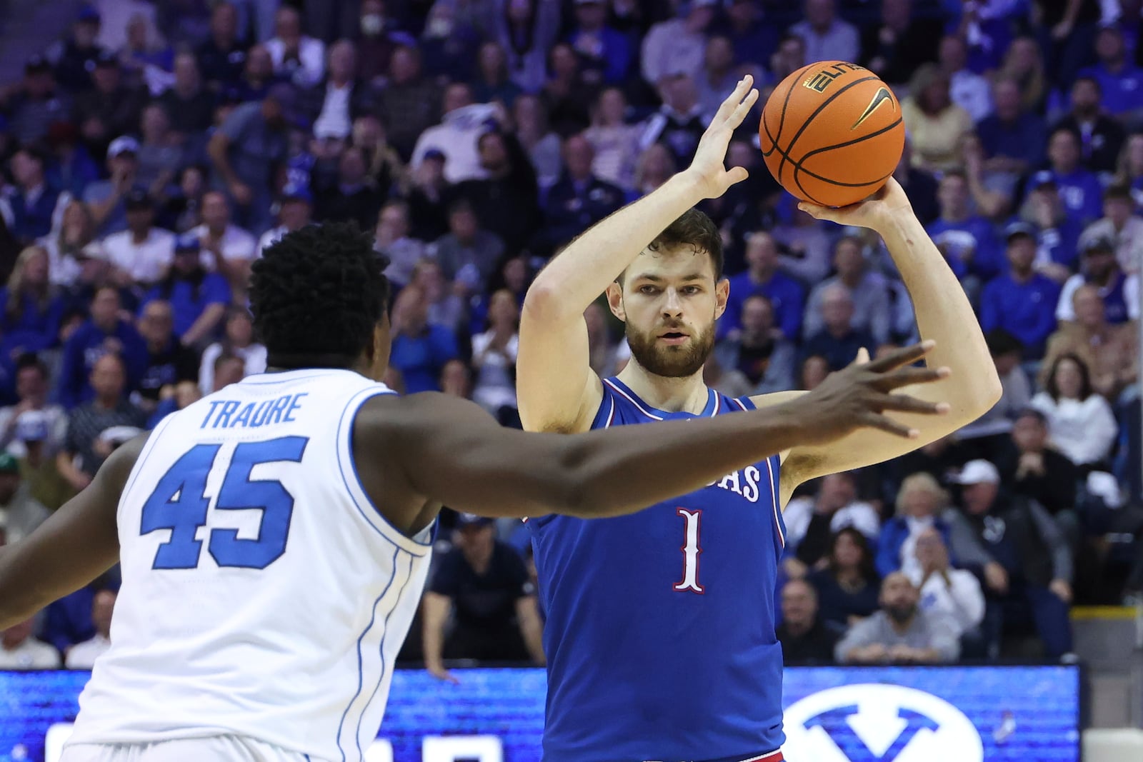 Kansas center Hunter Dickinson (1) holds the ball away from BYU center Fousseyni Traore (45) during the second half of an NCAA college basketball game, Tuesday, Feb. 18, 2025, in Provo, Utah. (AP Photo/Rob Gray)