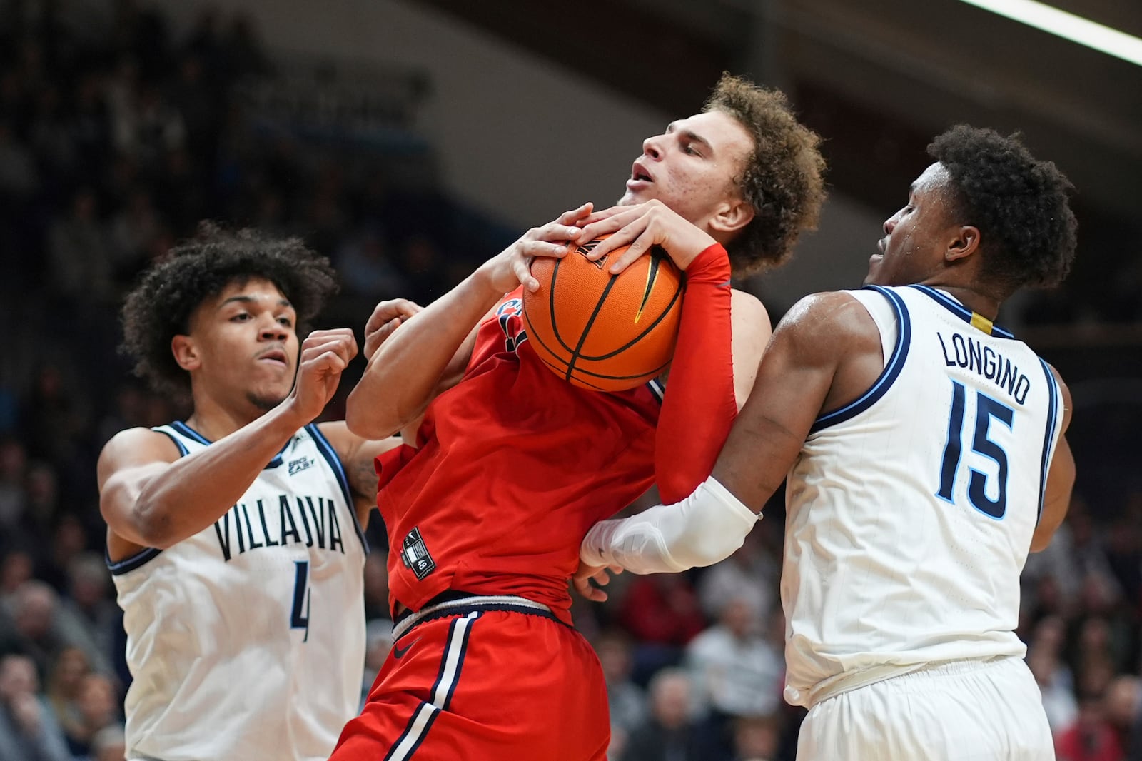 St. John's Ruben Prey, center, tries to hang onto the ball against Villanova's Jordan Longino, right, and Tyler Perkins during the first half of an NCAA college basketball game, Wednesday, Feb. 12, 2025, in Villanova, Pa. (AP Photo/Matt Slocum)