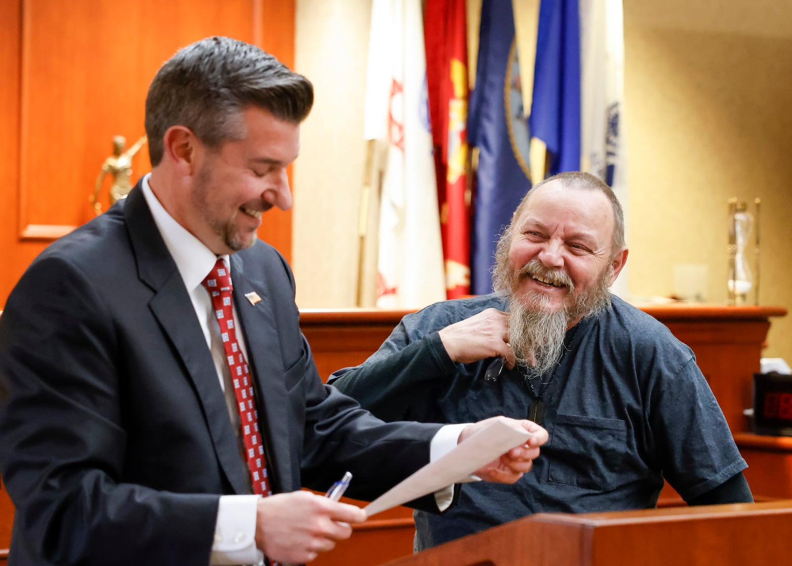 Judge Michael A. Oster Jr., left, signs the final papers for Army veteran Chris Bowlin during Veterans Treatment Court graduation Tuesday, Nov. 15, 2022 in Butler County Common Pleas Court in Hamilton. This class had three graduates for a combined total of 25 graduates since Veterans Treatment Court started in 2017. NICK GRAHAM/STAFF