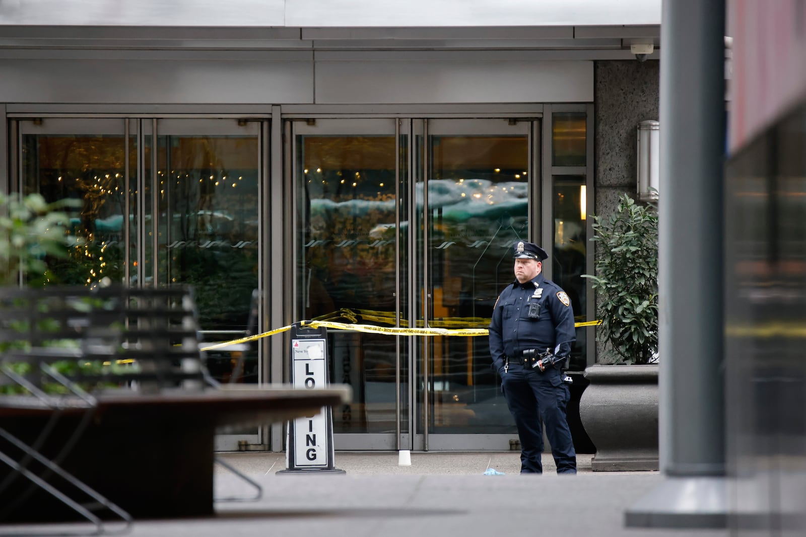 A New York police officer stands outside the Hilton Hotel in midtown Manhattan where Brian Thompson, the CEO of UnitedHealthcare, was fatally shot Wednesday, Wednesday, Dec. 4, 2024, in New York. (AP Photo/Stefan Jeremiah)