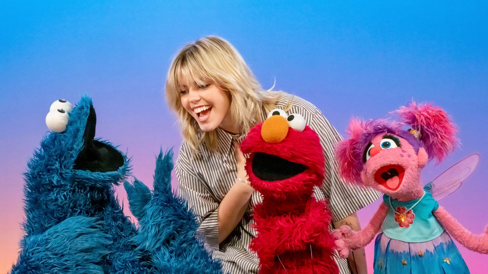 This image released by Sesame Workshop shows actor-singer Renee Rapp with muppet characters Cookie Monster, from left, Elmo and Abby Cadabby on the set of "Sesame Street." (Richard Termine/Sesame Workshop via AP)