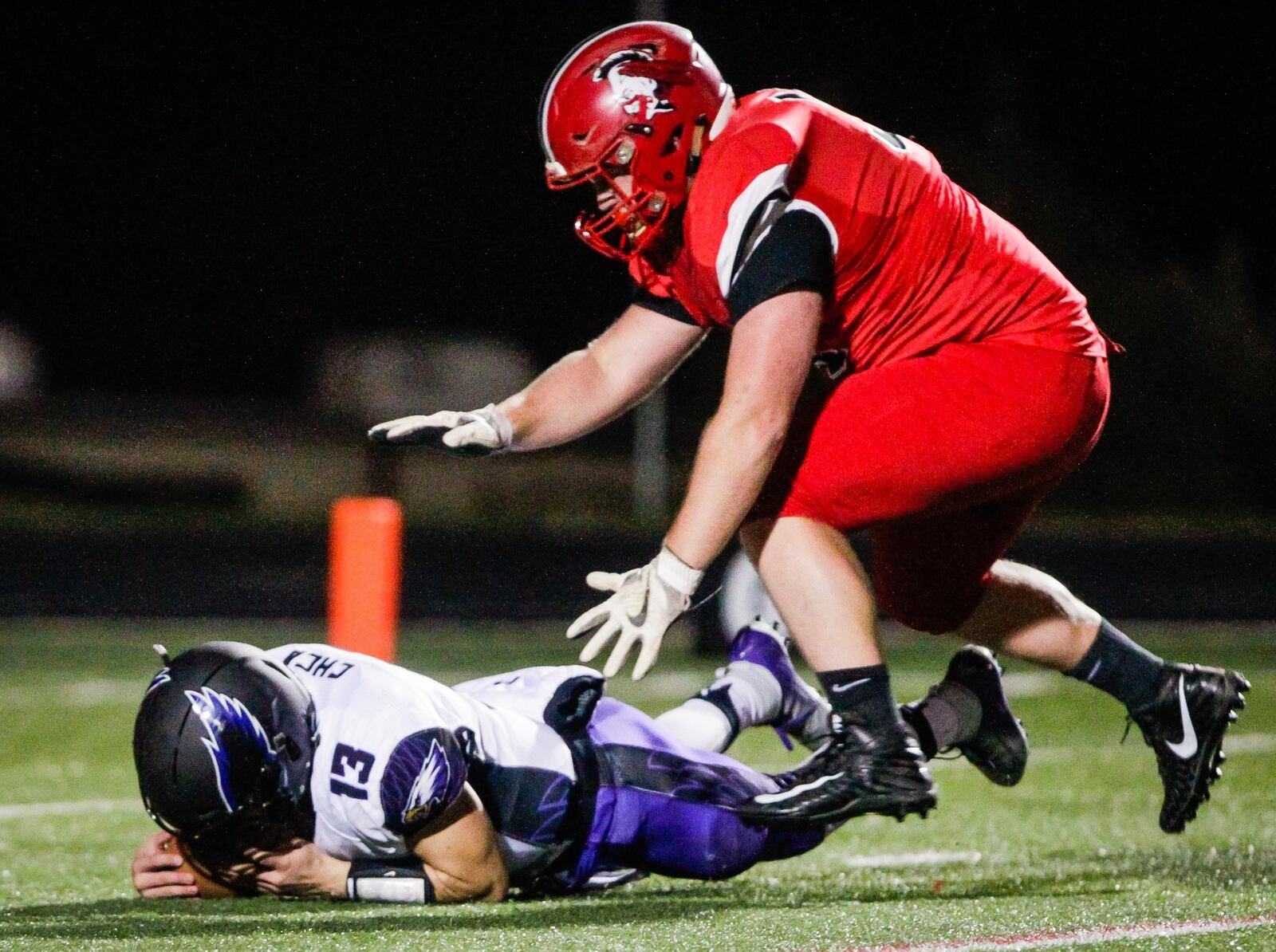 Madison’s Max Evans is about to make sure Cincinnati Hills Christian Academy quarterback Cole Fisher is officially down Saturday night at Lakota East. Madison won the Division V, Region 20 playoff semifinal 50-6. NICK GRAHAM/STAFF