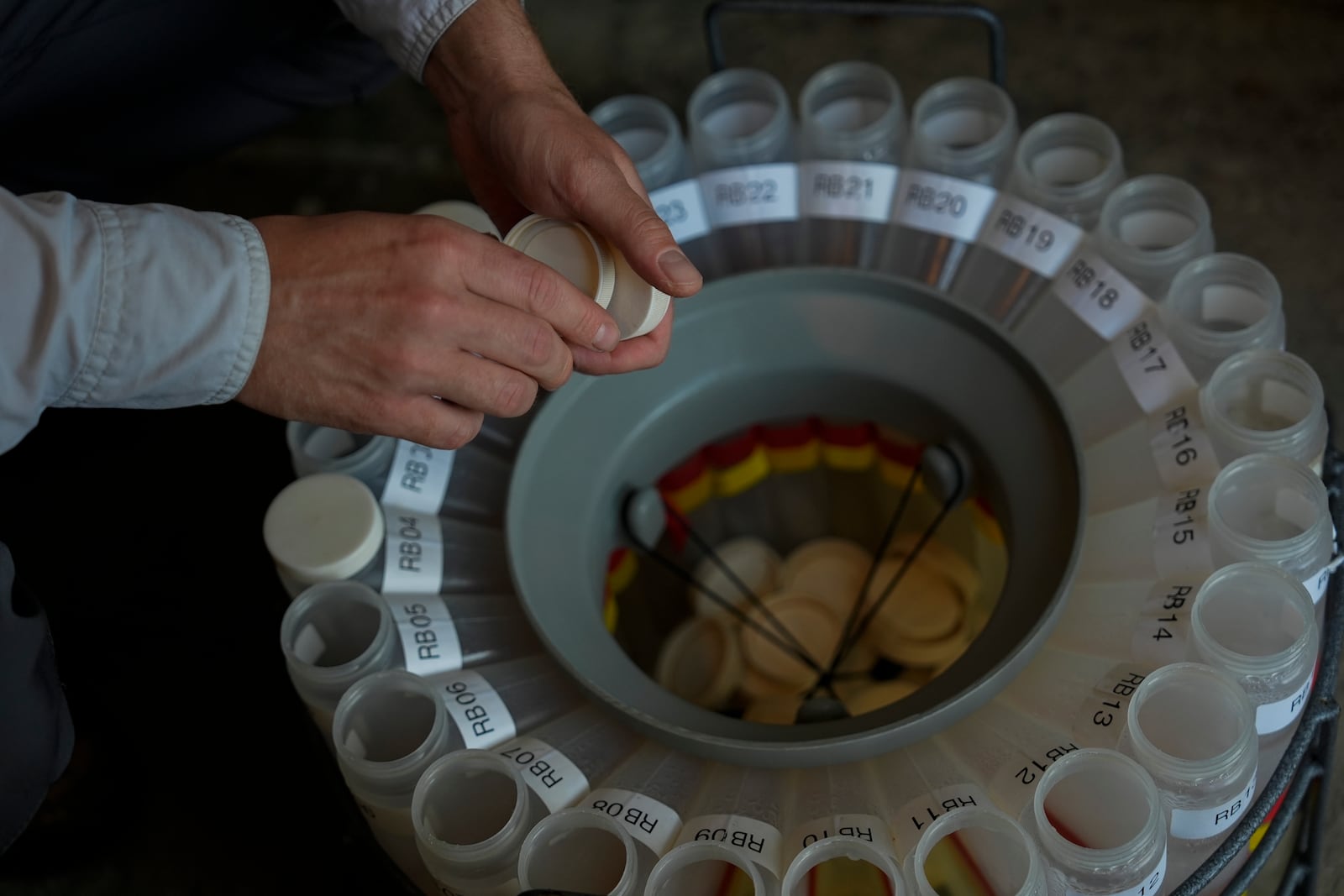 Jake Boehler, field manager at the National Center for Water Quality Research, collects water samples from a monitoring station, Monday, Aug. 26, 2024, in Woodville, Ohio. (AP Photo/Joshua A. Bickel)