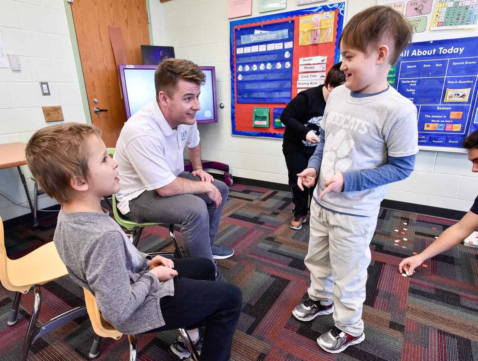 Sean McKeon, middle, a Miami University senior majoring in finance and accounting, plays a game with third graders Gabe Sizemore, left, and Noah Trumball at Bridgeport Elementary School Friday, Dec. 7 in Hamilton. McKeon and other members of the Pi Kappa Phi fraternity he is in volunteer with special needs students at the school and he has developed a special relationship with the elementary students. NICK GRAHAM/STAFF