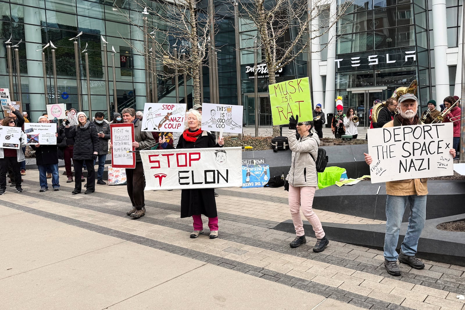 Protesters rally outside of a Tesla store in Boston, Saturday, March 1, 2025, against the company's CEO, Elon Musk, who is leading an effort to cut government jobs on behalf of President Donald Trump. (AP Photo/Rodrique Ngowi)