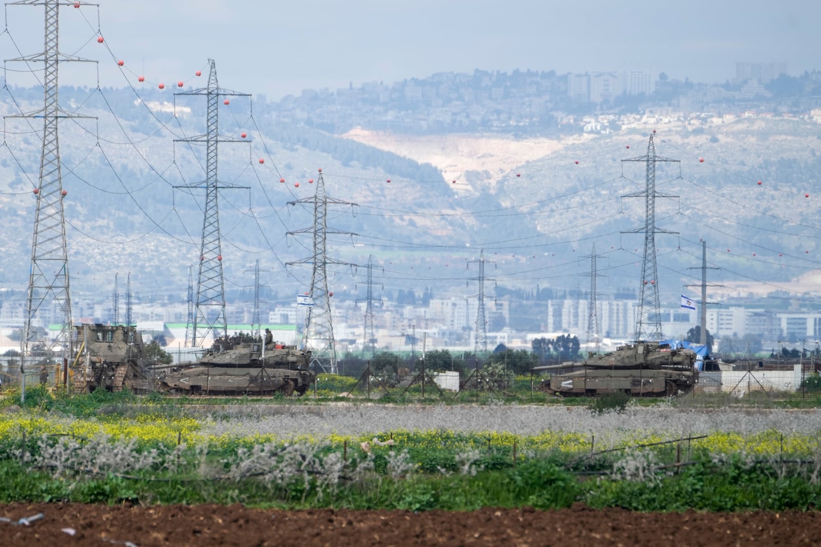 Israeli tanks gather outside of the occupied West Bank near Jenin, Sunday, Feb. 23, 2025. (AP Photo/Majdi Mohammed)