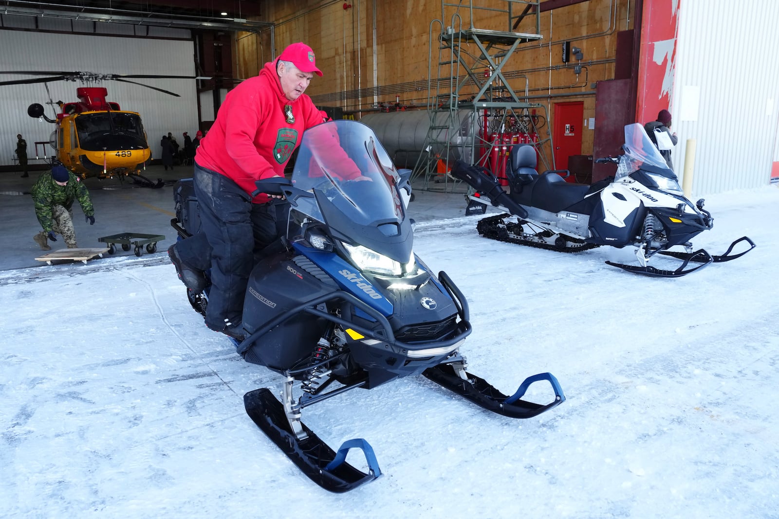 Members of the Canadian Rangers clean up after an announcement by Prime Minister Mark Carney at a Canadian Armed Forces forward-operating location in Iqaluit, Nunavut, on Tuesday, March 18, 2025. (Sean Kilpatrick/The Canadian Press via AP)