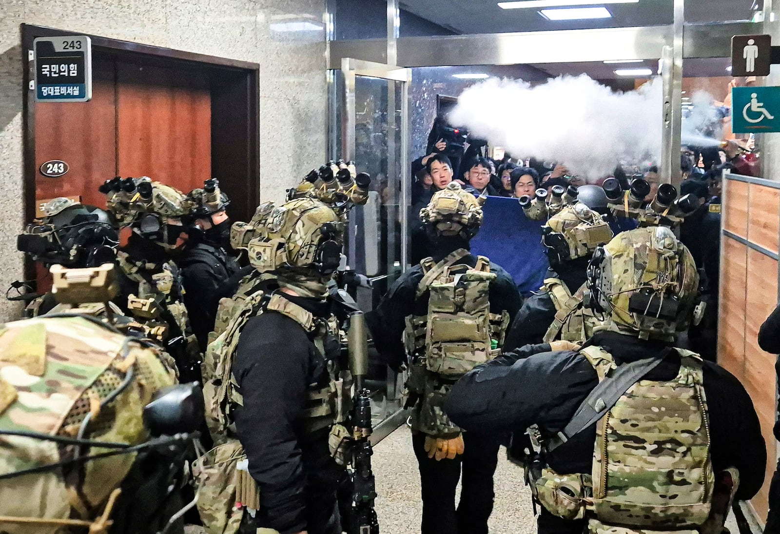 A National Assembly staff sprays fire extinguishers to block soldiers entering the main hall of the National Assembly in Seoul, South Korea, Wednesday, Dec. 4, 2024. (Jo Da-un/Yonhap via AP)