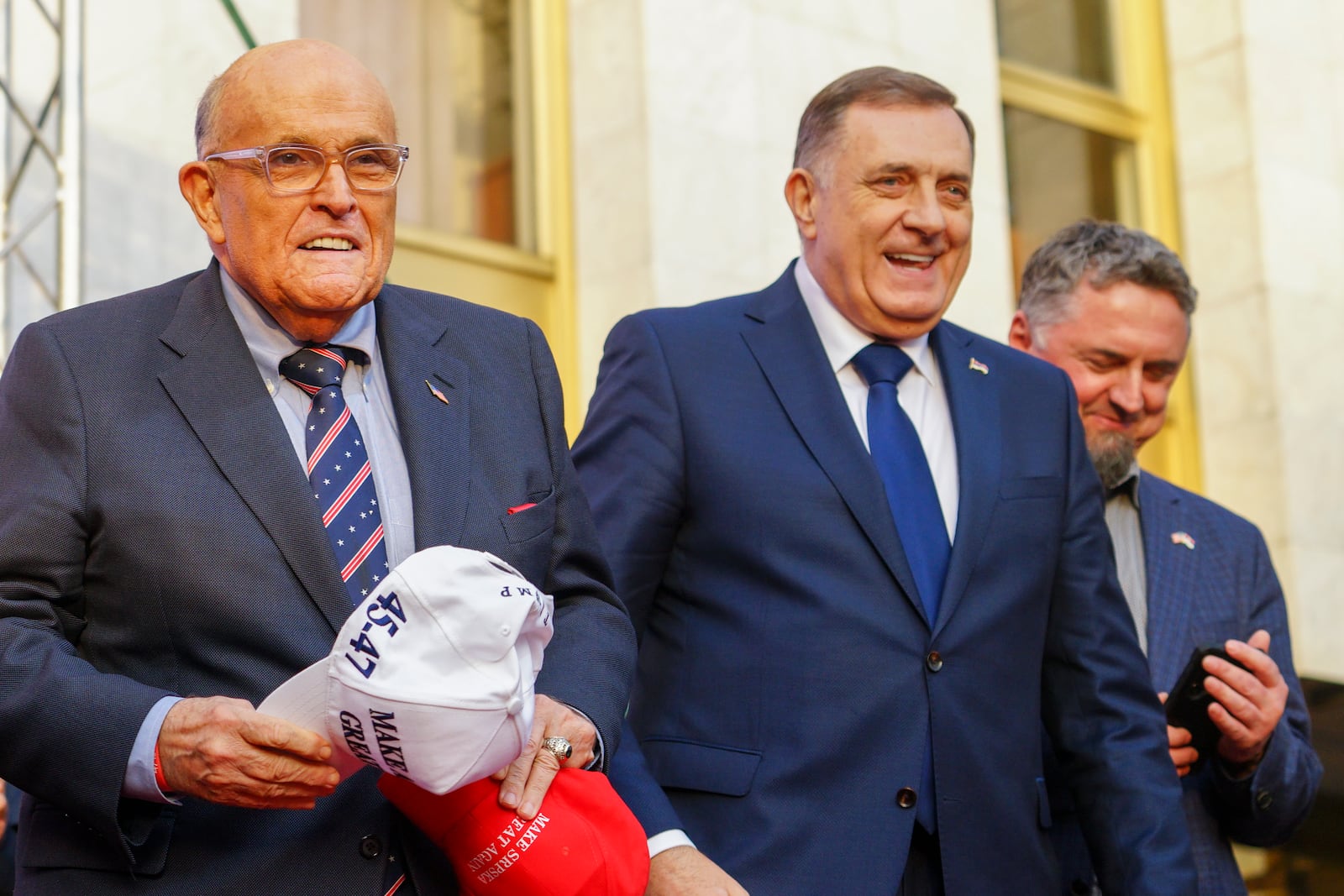 Bosnian Serb President Milorad Dodik, center, and former New York City mayor Rudy Giuliani, left, smile, during a rally on the eve of a scheduled court verdict that could order the pro-Russia Serb leader banned from politics or even sentenced to prison in the Bosnian town of Banja Luka, 240 kms northwest of Sarajevo, Tuesday, Feb. 25, 2025. (AP Photo/Radivoje Pavicic)