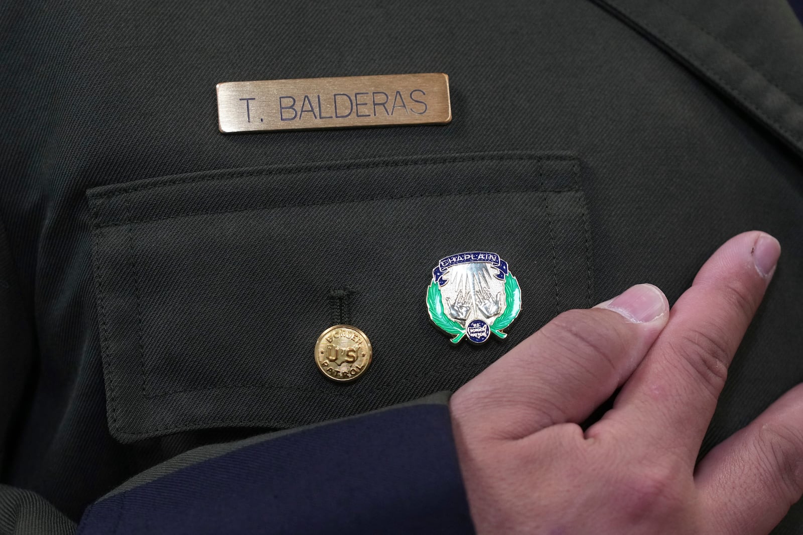 Border Patrol Agent Trinidad Balderas looks at his new chaplain pin after graduating from the program, Thursday, Nov. 21, 2024, in Dania Beach, Fla. (AP Photo/Marta Lavandier)