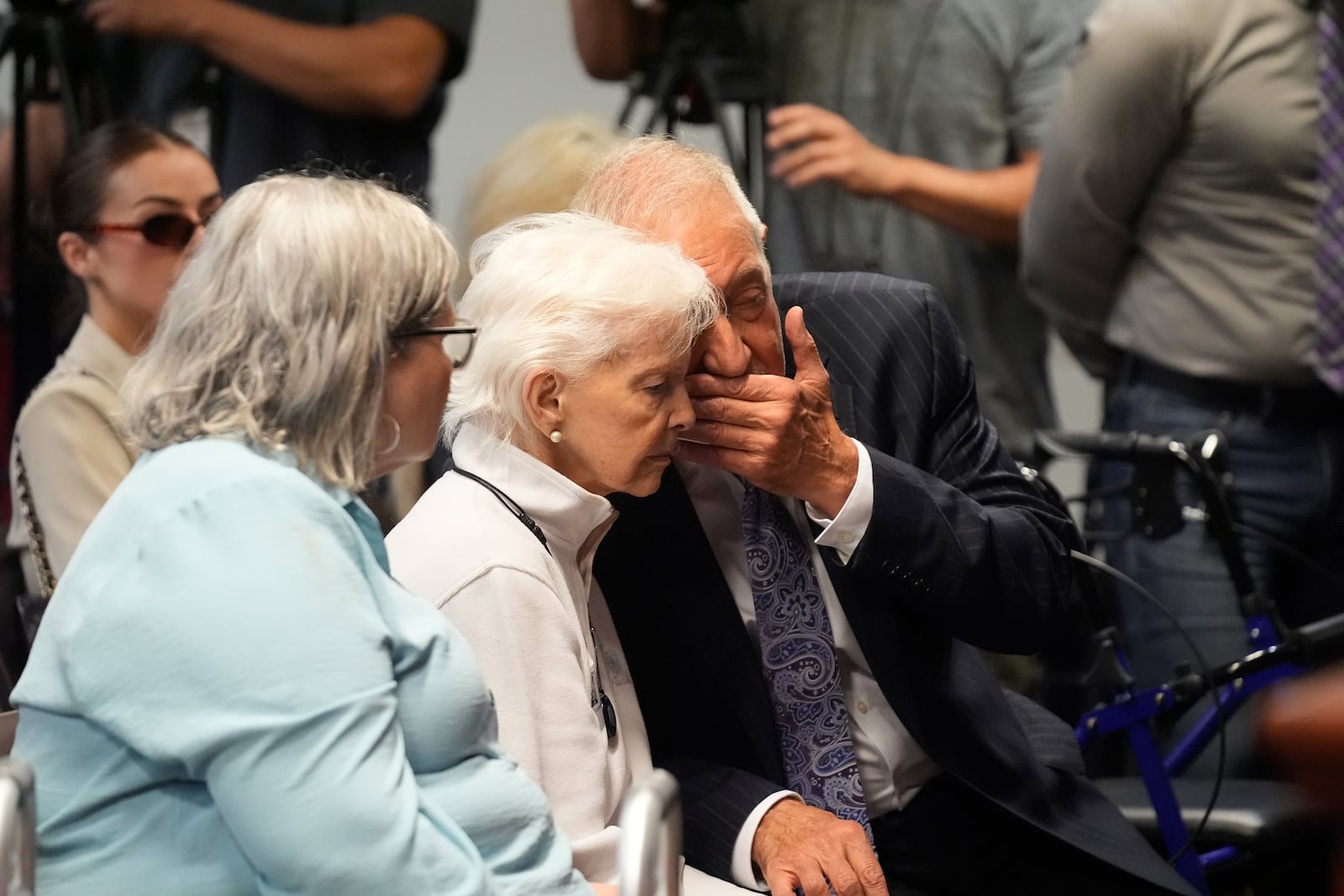 Kitty Menendez's sister, Joan Andersen VanderMolen, center, listens to Defense Attorney Mark Geragos, right, as Diane Hernandez niece of Kitty Menendez, left, looks on prior to a news conference being held by Los Angeles County District Attorney George Gascon at the Hall of Justice on Thursday, Oct. 24, 2024, in Los Angeles (AP Photo/Damian Dovarganes)