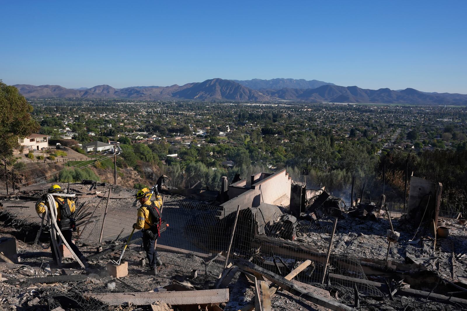 Los Angeles Fire Department firefighters work at a home destroyed by the Mountain Fire in Camarillo, Calif., Friday, Nov. 8, 2024. (AP Photo/Jae C. Hong)