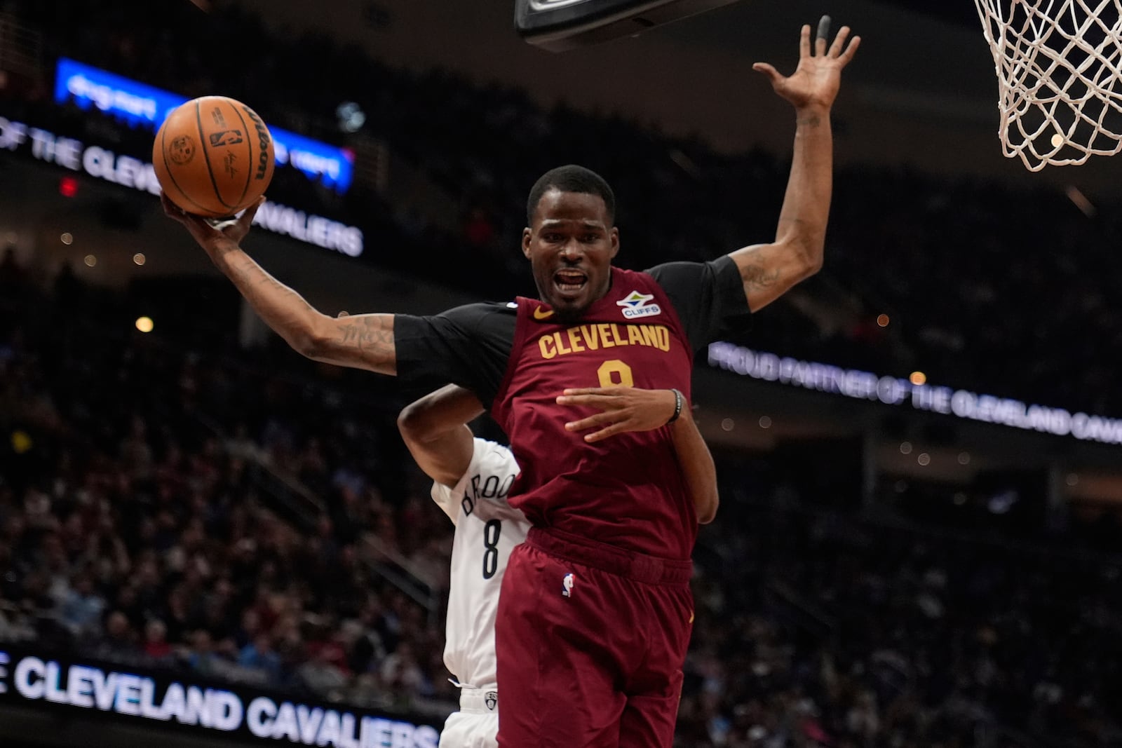 Cleveland Cavaliers guard Javonte Green (8) is fouled from behind by Brooklyn Nets forward Ziaire Williams, rear, in the first half of an NBA basketball game Tuesday, March 11, 2025, in Cleveland. (AP Photo/Sue Ogrocki)