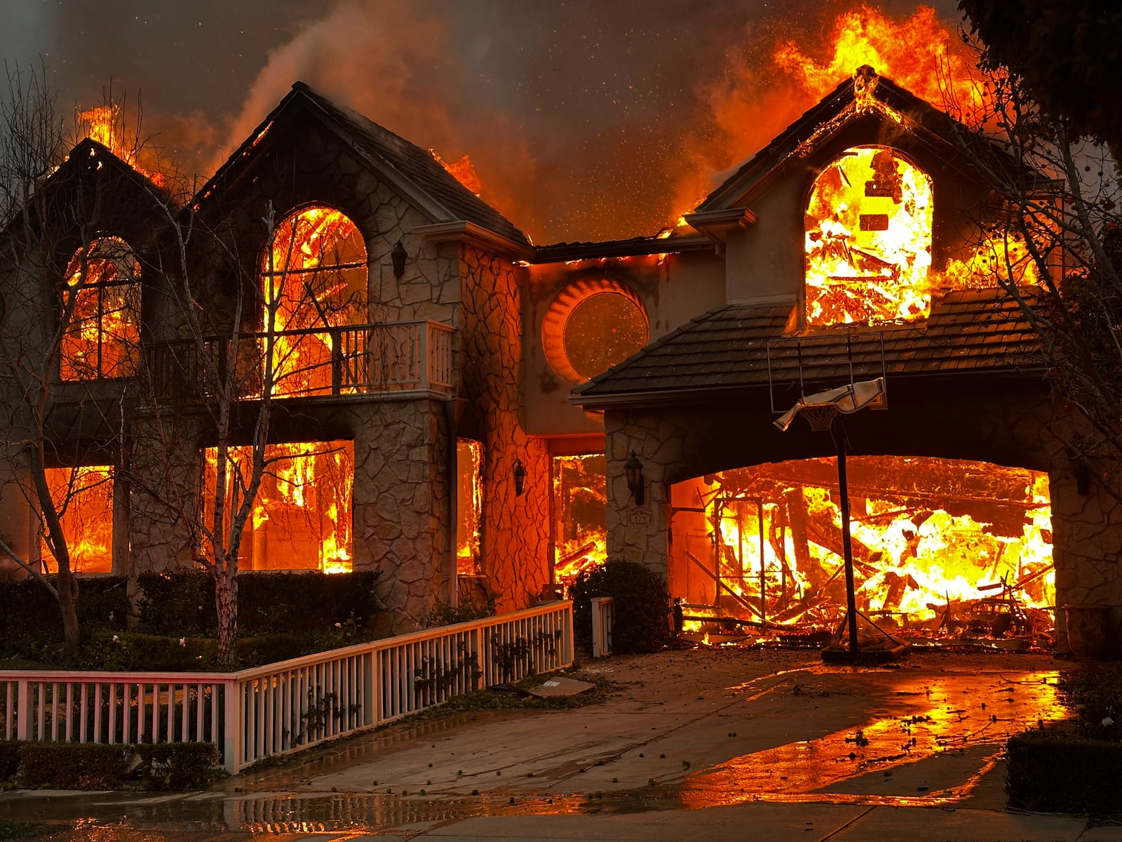 The Palisades Fire burns a structure in the Pacific Palisades neighborhood of Los Angeles, Wednesday, Jan. 8, 2025. (AP Photo/Eugene Garcia)