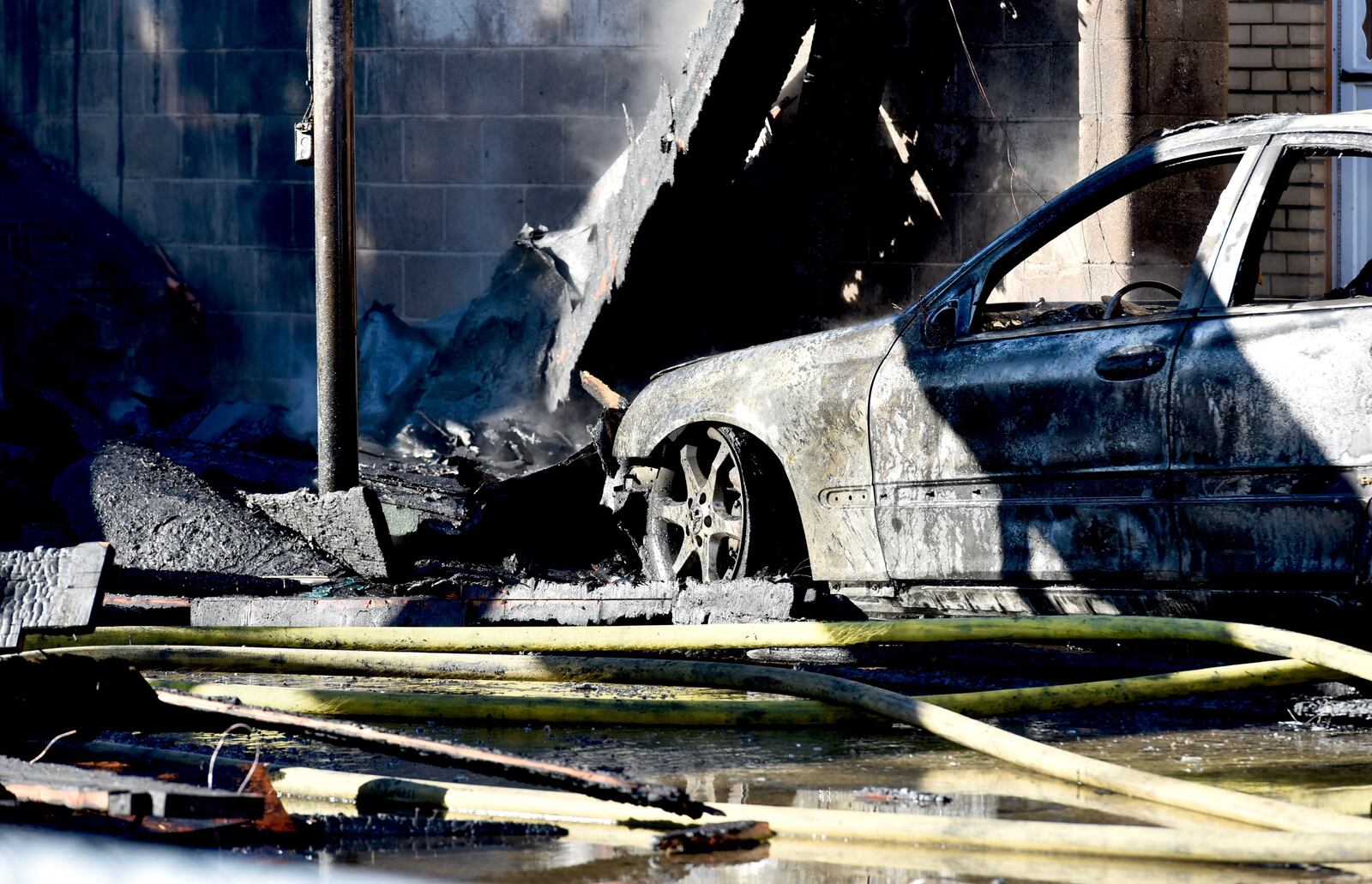 Several cars were heavily burned in a fire at a garage behind apartments on Arlington Avenue in Hamilton on Monday, Feb. 25, 2019. NICK GRAHAM / STAFF