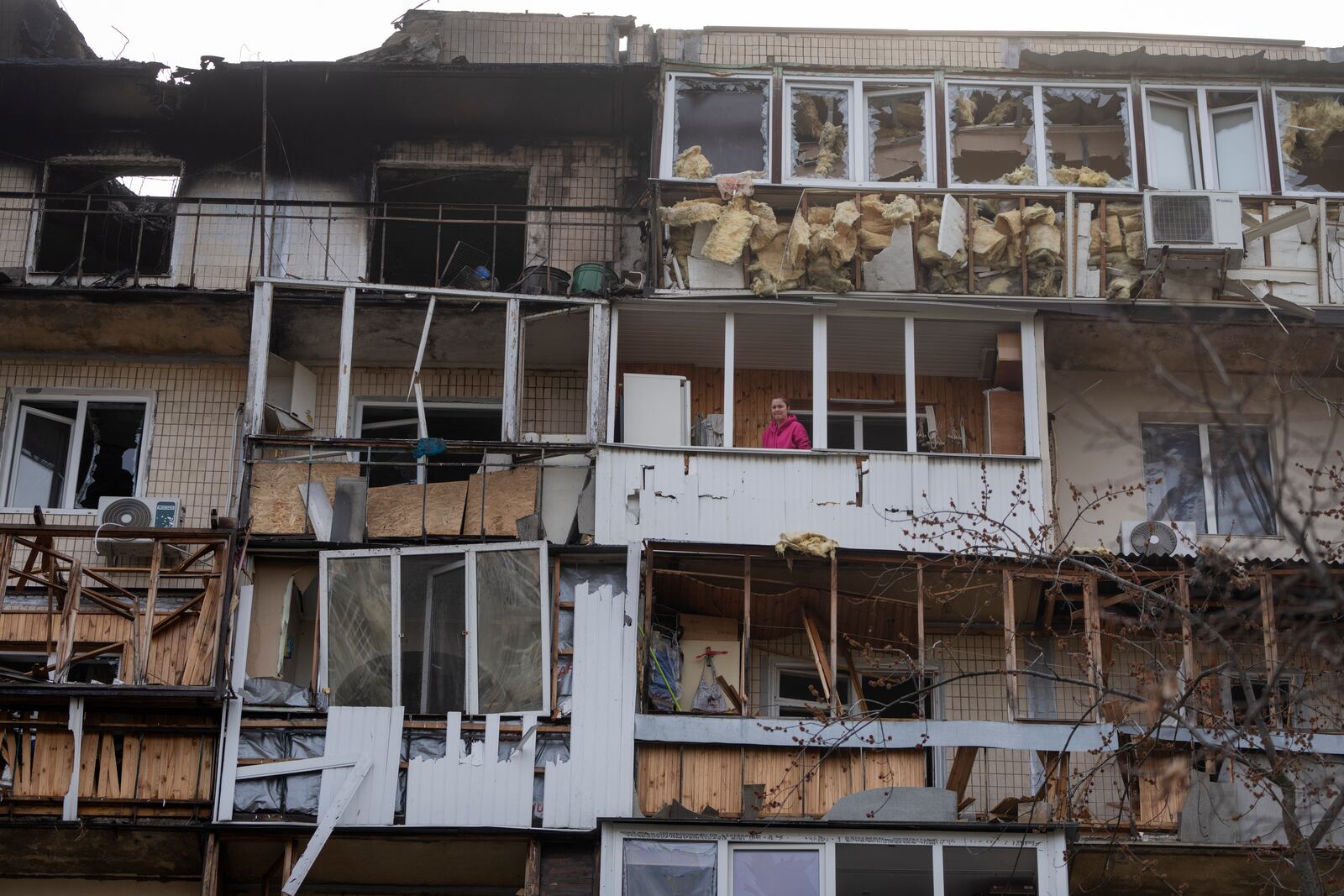 A resident cleans up the damaged apartment in a multi-storey house after Russia's night drone attack, in Kyiv, Ukraine, Sunday, March 23, 2025. (AP Photo/Efrem Lukatsky)